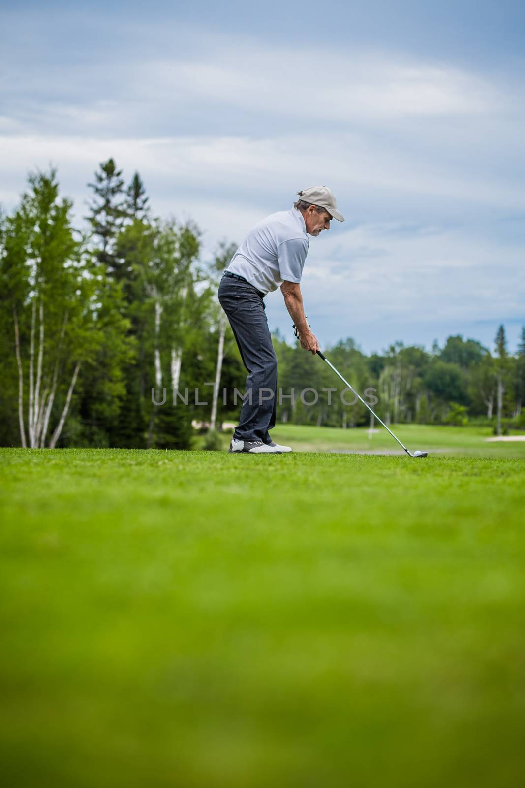 Mature Golfer on a Golf Course with room for your text (ready to swing)