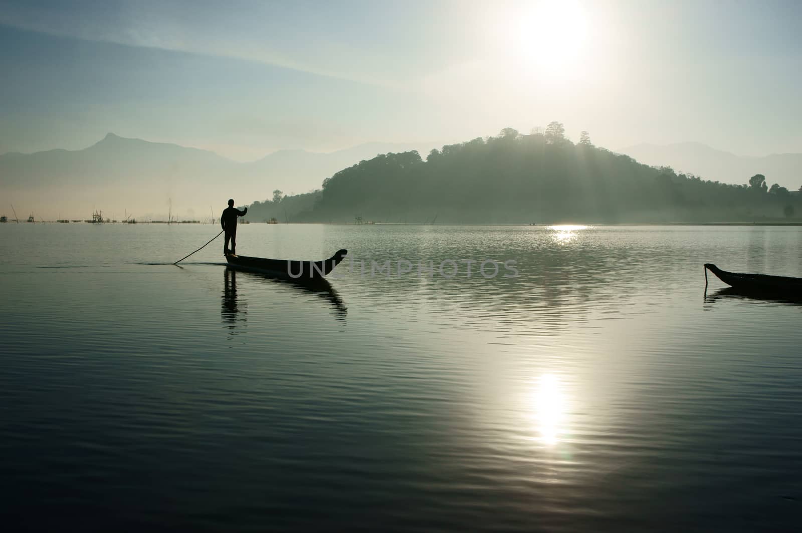 sunrise on lake,fisherman rowing the boat by xuanhuongho