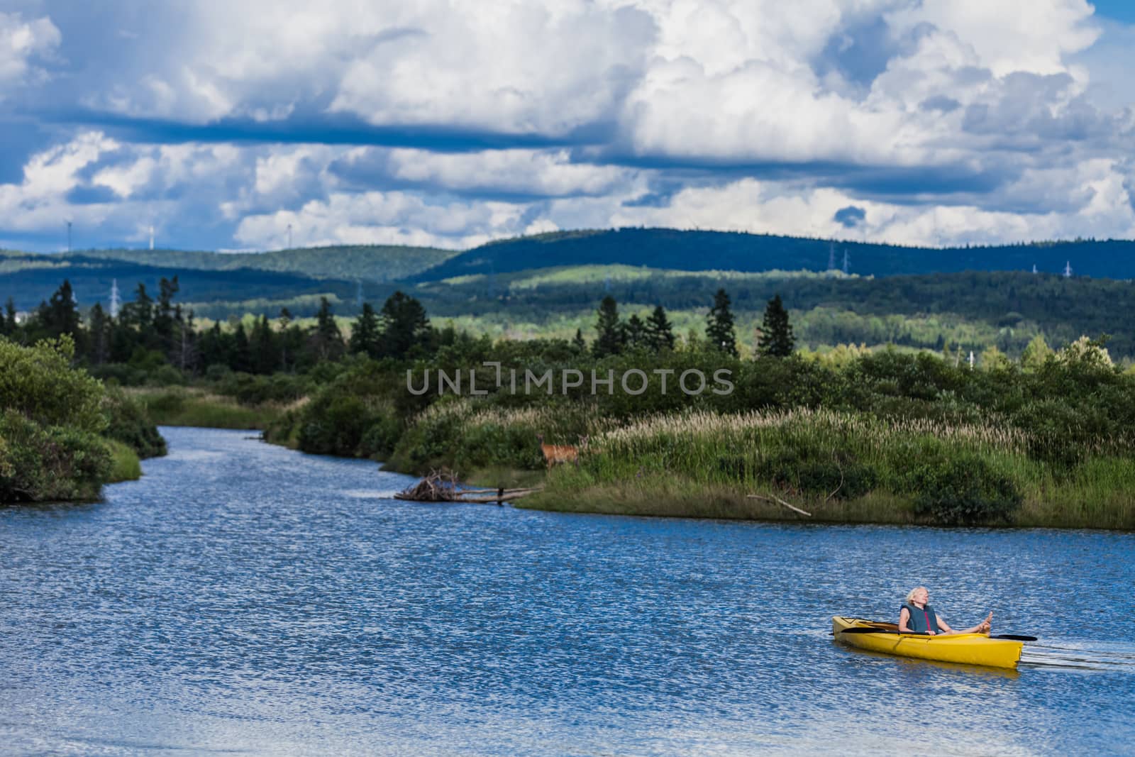 Calm River and Woman relaxing in a Kayak by aetb