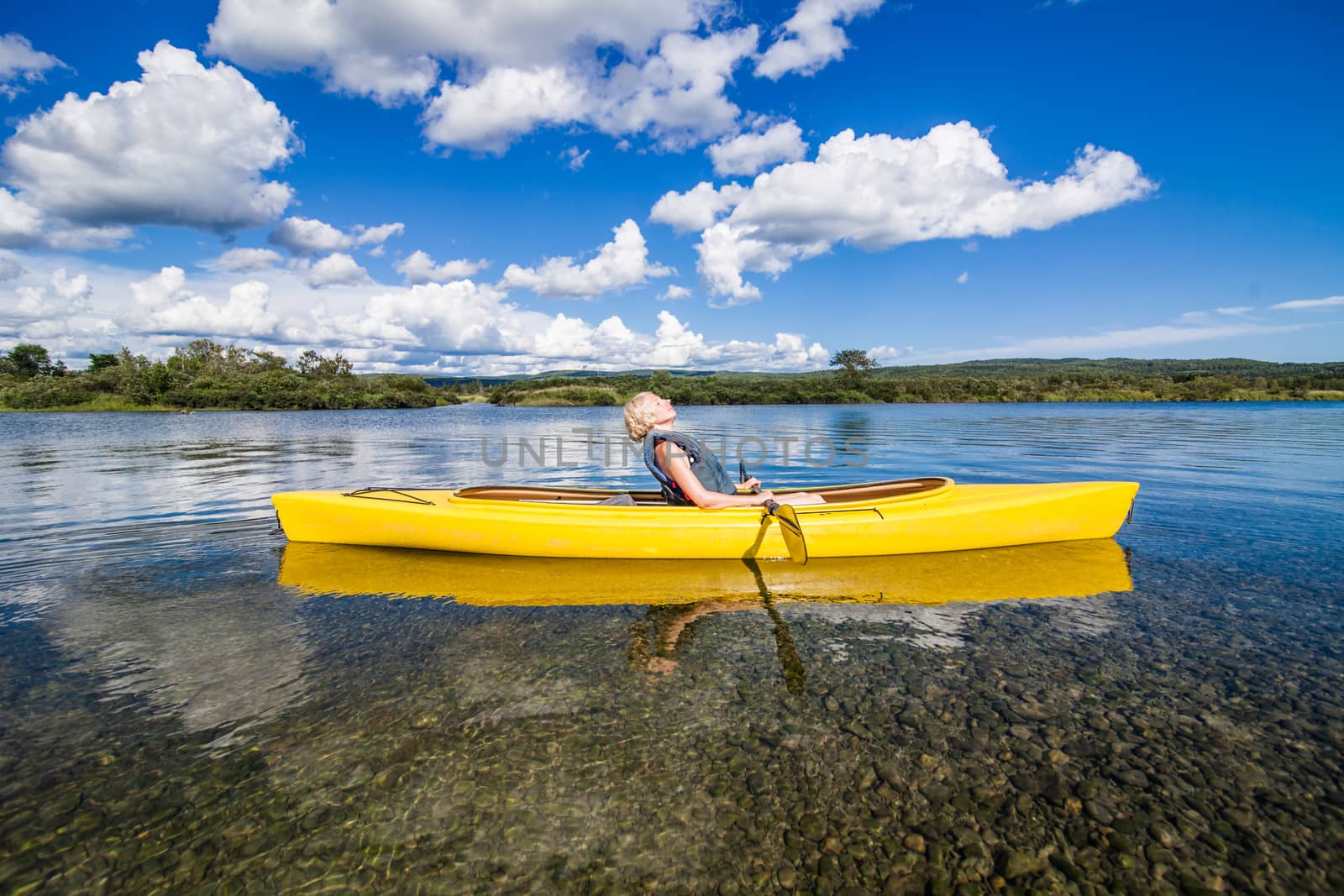 Calm River and Woman relaxing in a Kayak by aetb