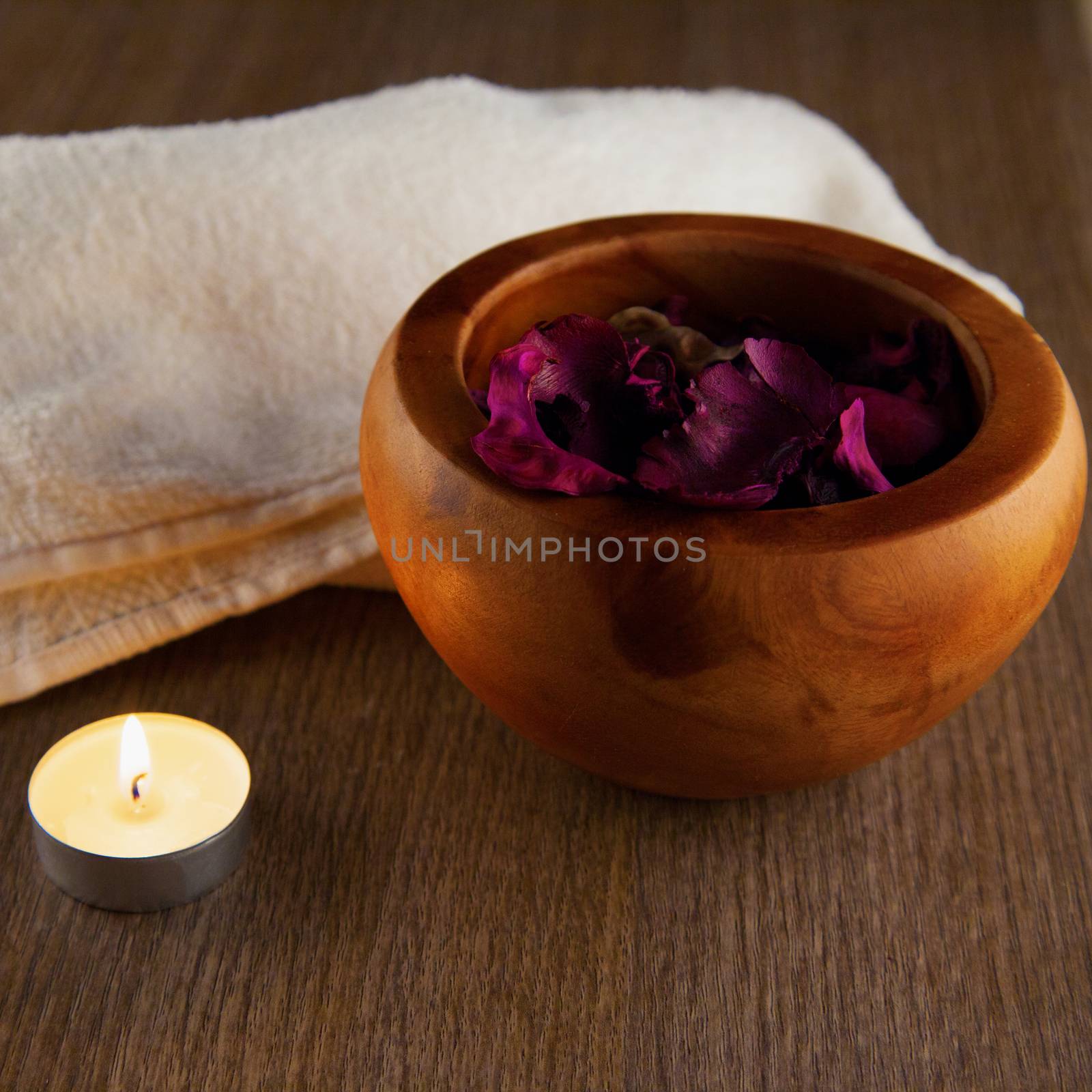 Pot pourri in wooden cup, candle and towel