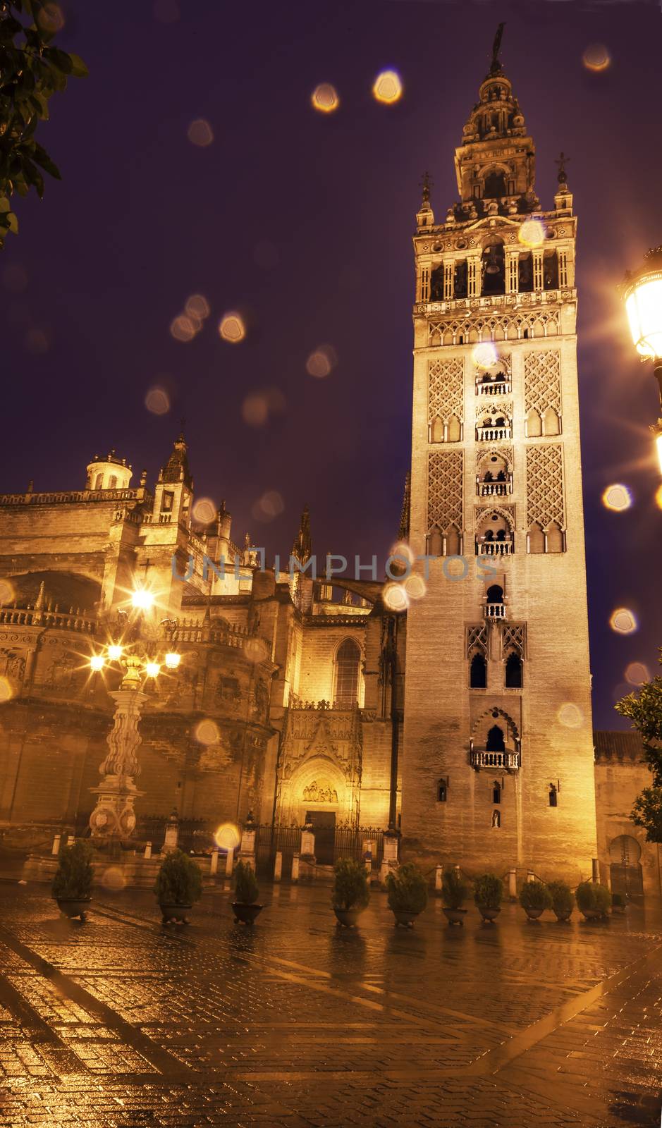 Giralda Spire, Bell Tower, Seville Cathedral, Rainy Night, Seville, Andalusia Spain.  Built in the 1500s.  Largest Gothic Cathedral in the World and Third Largest Church in the World.  Burial Place of Christopher Columbus.  Giralda is a former minaret converted into a bell tower