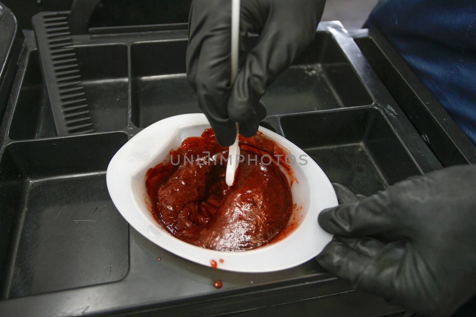 Hairdresser preparing bowl with peroxide for hair dyeing treatment, closeup