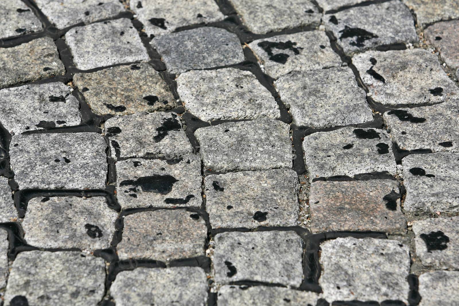 small cobblestone sidewalk made of cubic stones structured background