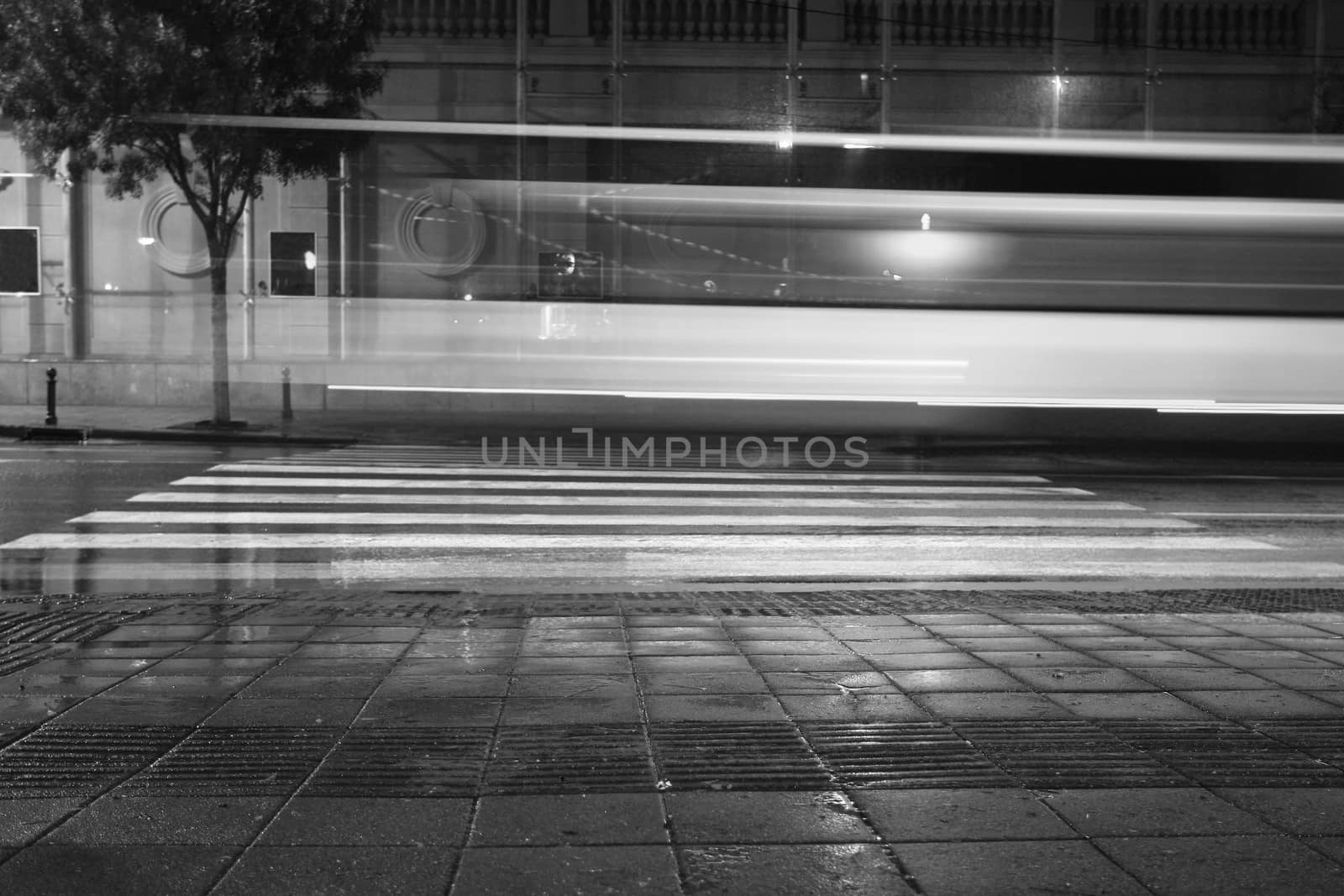 Long exposure in night traffic on road and pedestrian crossing
