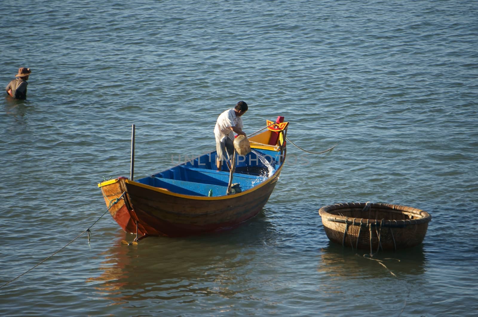 PHAN THIET, VIET NAM- FEB 3: Fisherman wash the hold of boat with water at seashore  in Phan Thiet, Viet Nam on Feb 3, 2013