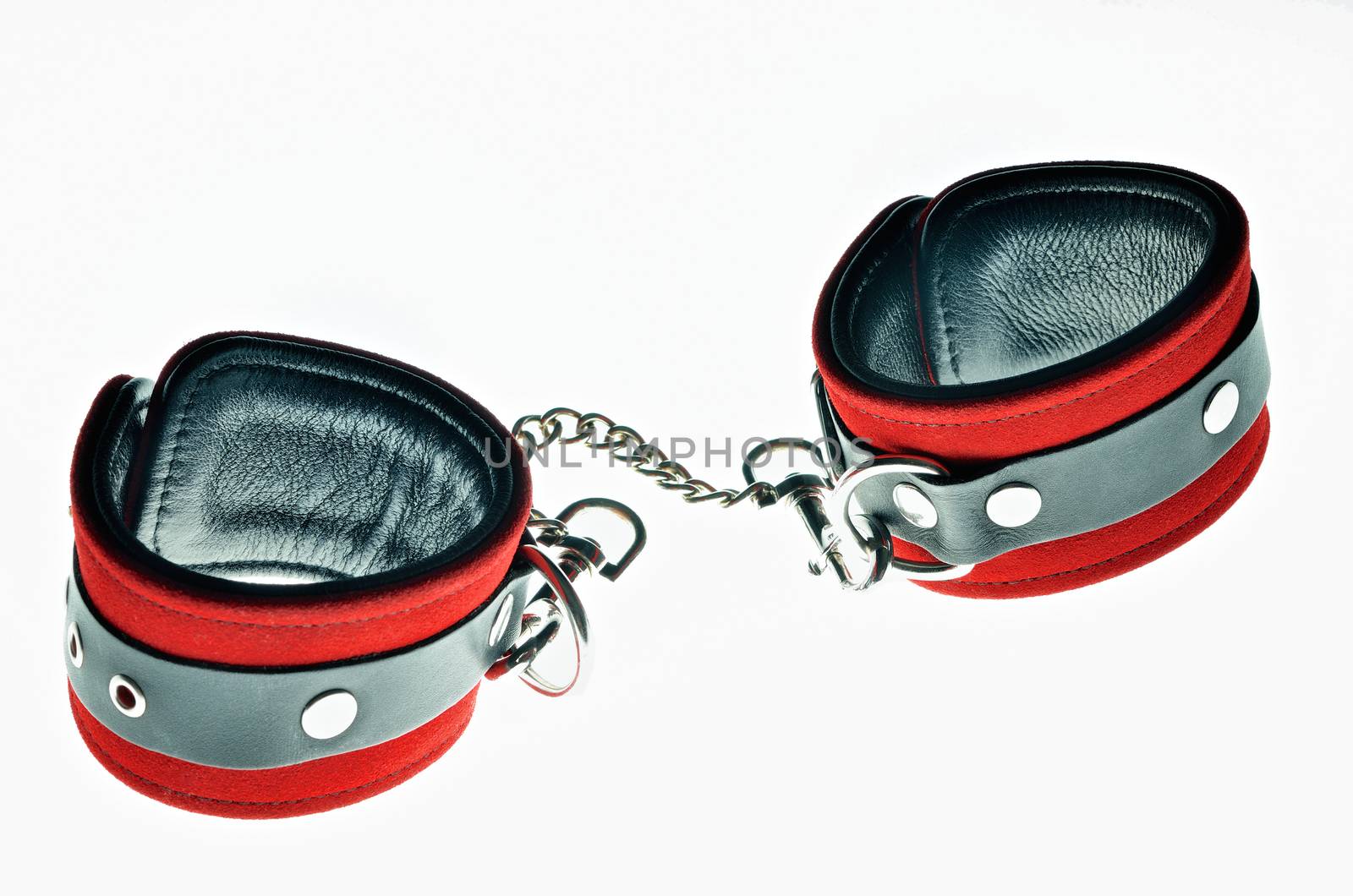 Red leather handcuffs in white background