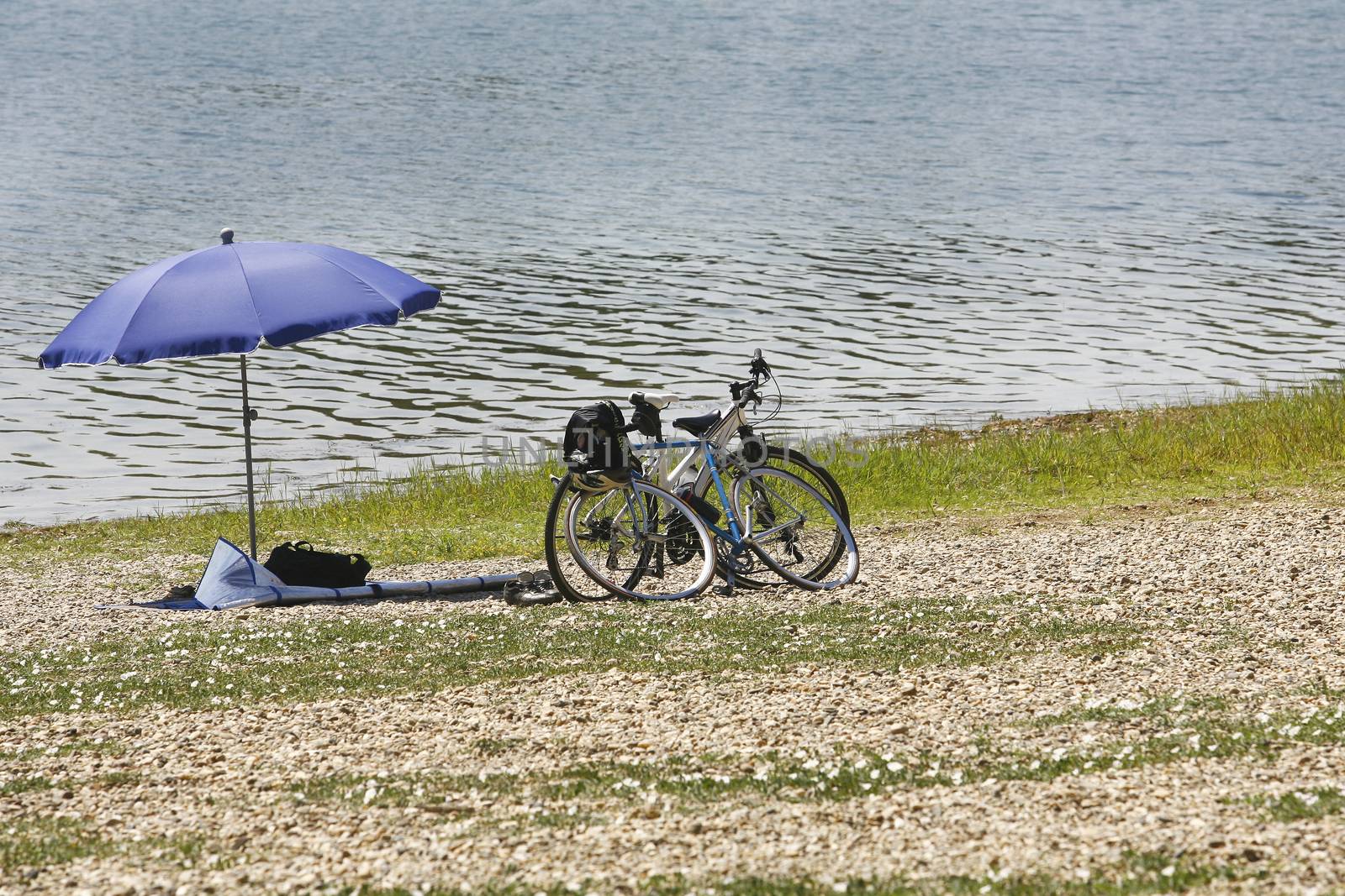 sunshade umbrella on lake Beach and two bicycle
