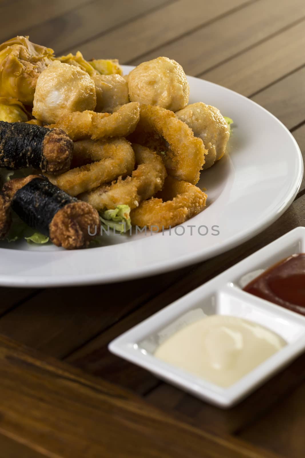 A vertical shot of a plate of fried finger food snack ready to be served. 