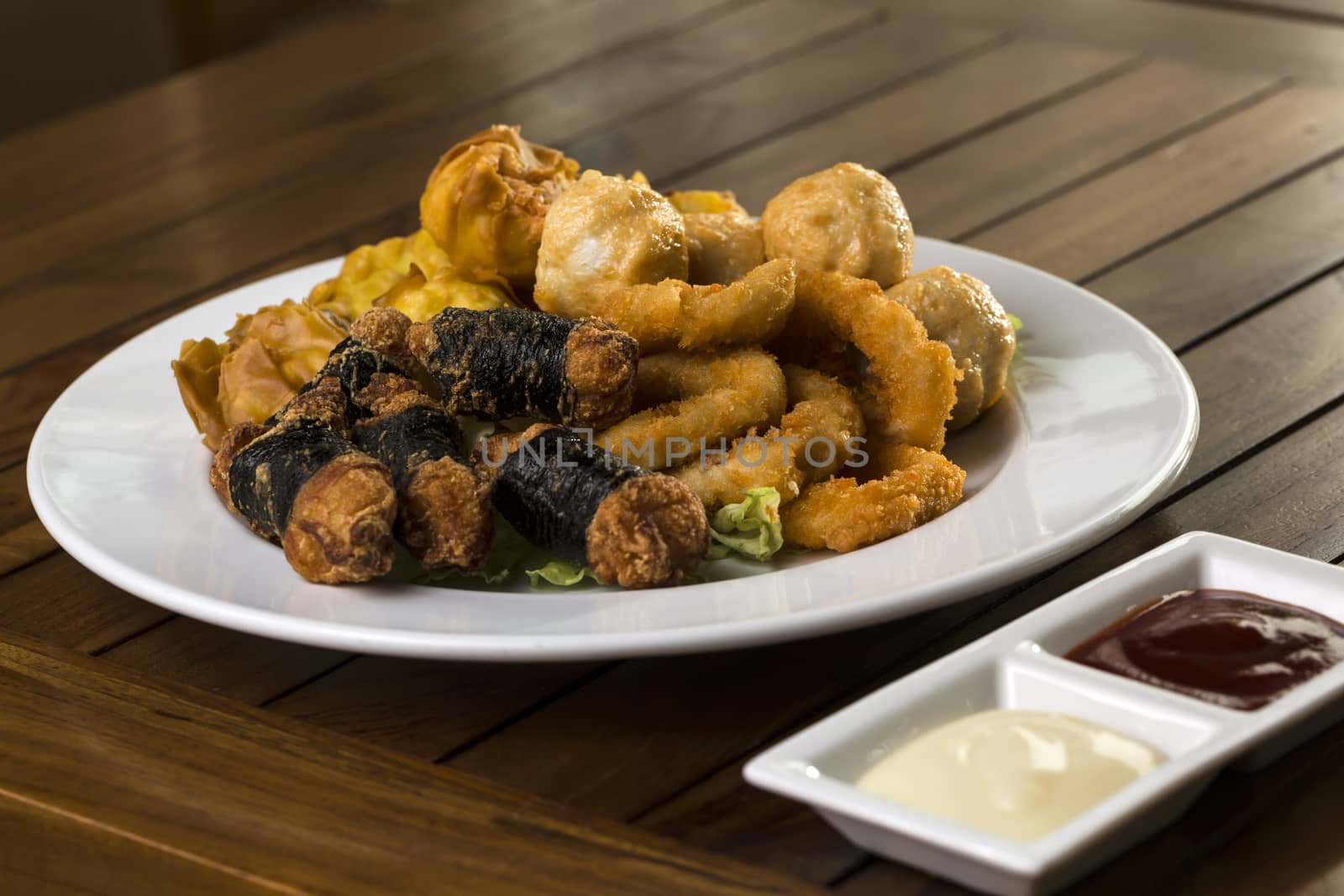 A hortizontal shot of a plate of fried finger food snack ready to be served.