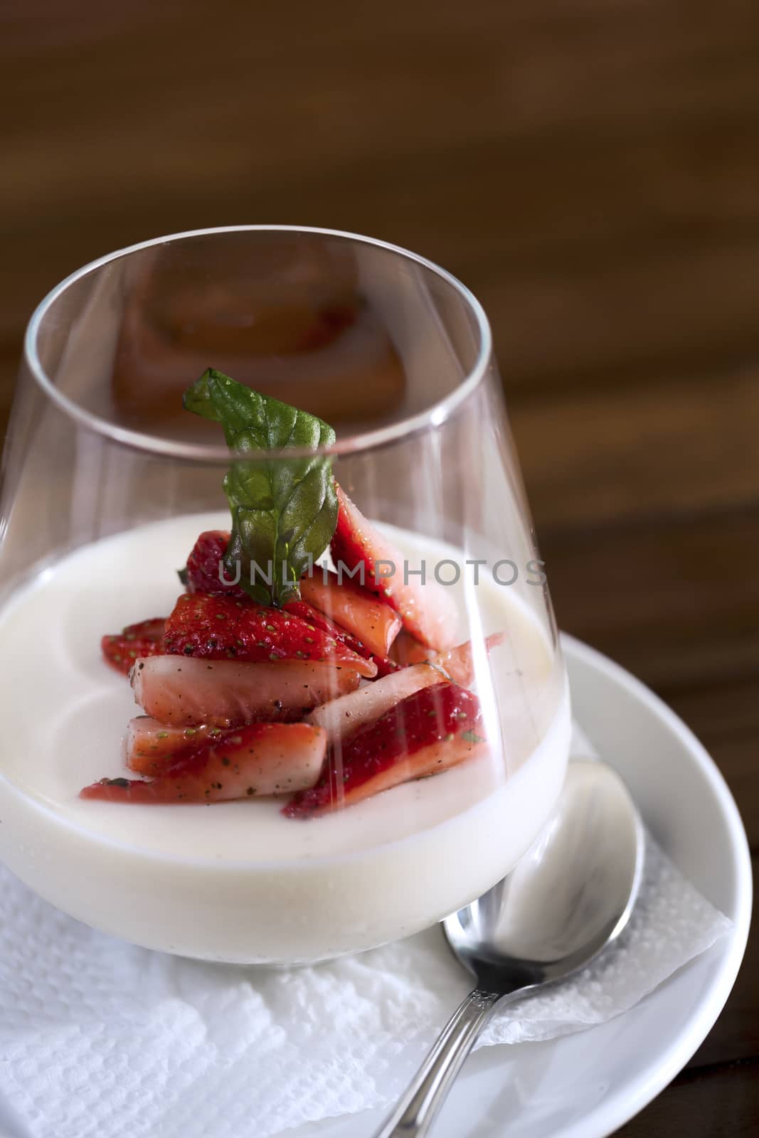 A vertical shot of a strawberry dessert in a glass ready to be served.