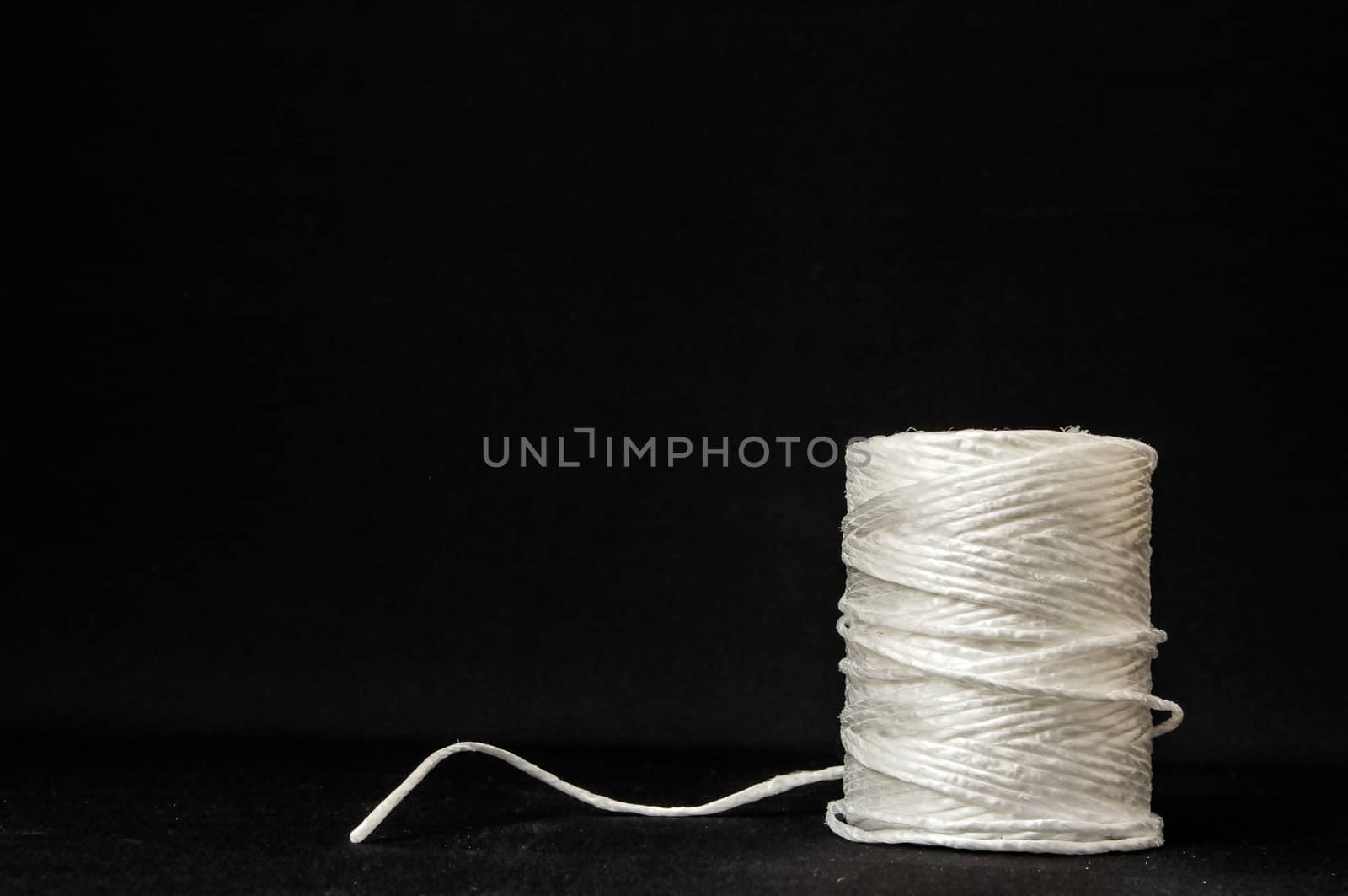 Roll of White Twine on a Black Background