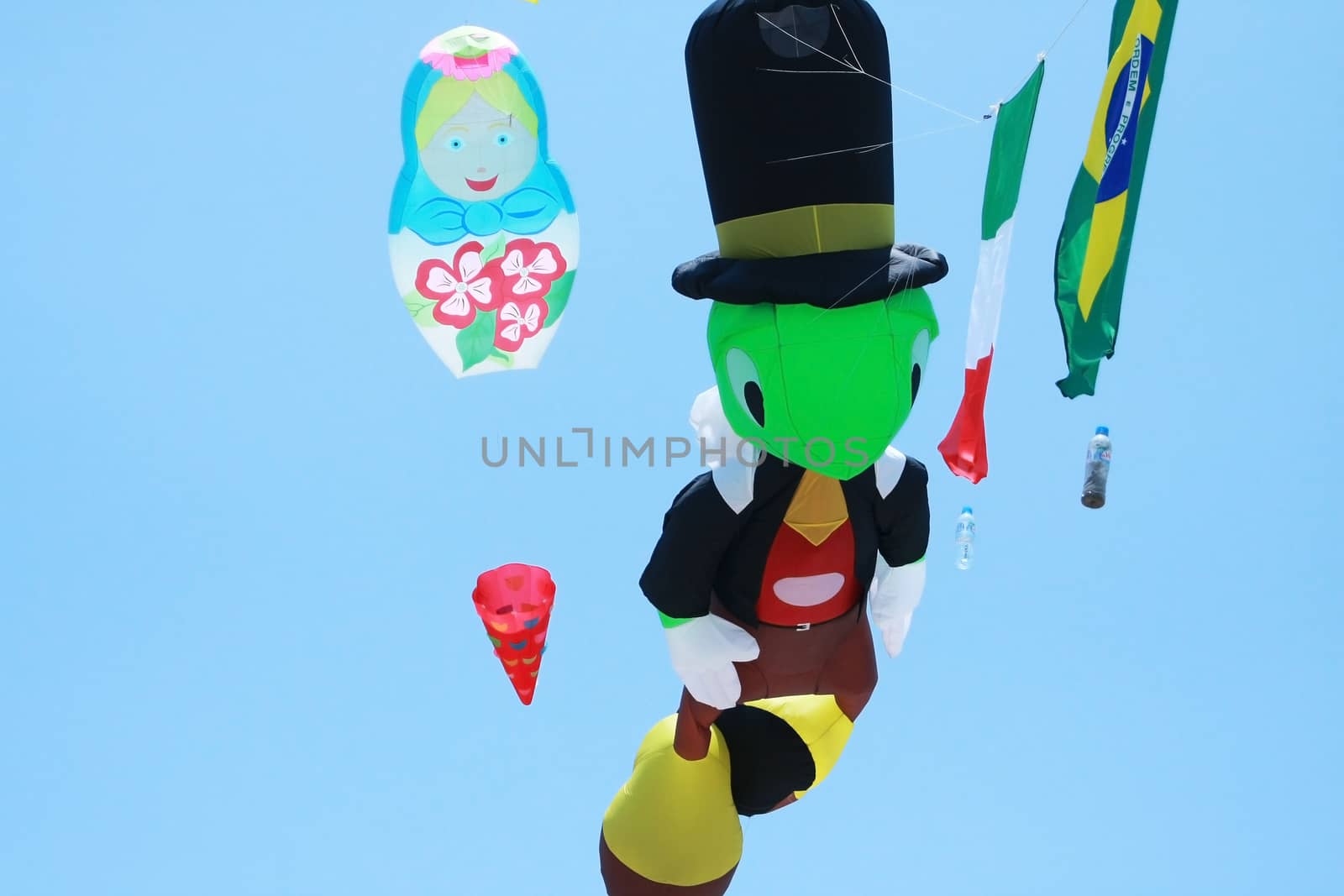 Kite with cartoon character's shape flying in the air against blue sky
