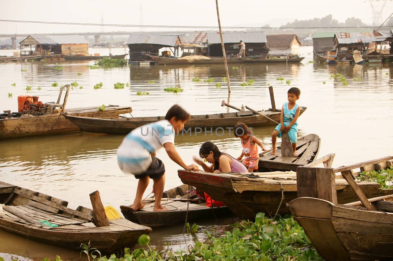 LA NGA, VIET NAM- SEPTEMBER 6: Life at La Nga fishing village, the family go up the boat to come houseboat in La Nga, VietNam on September 6, 2013