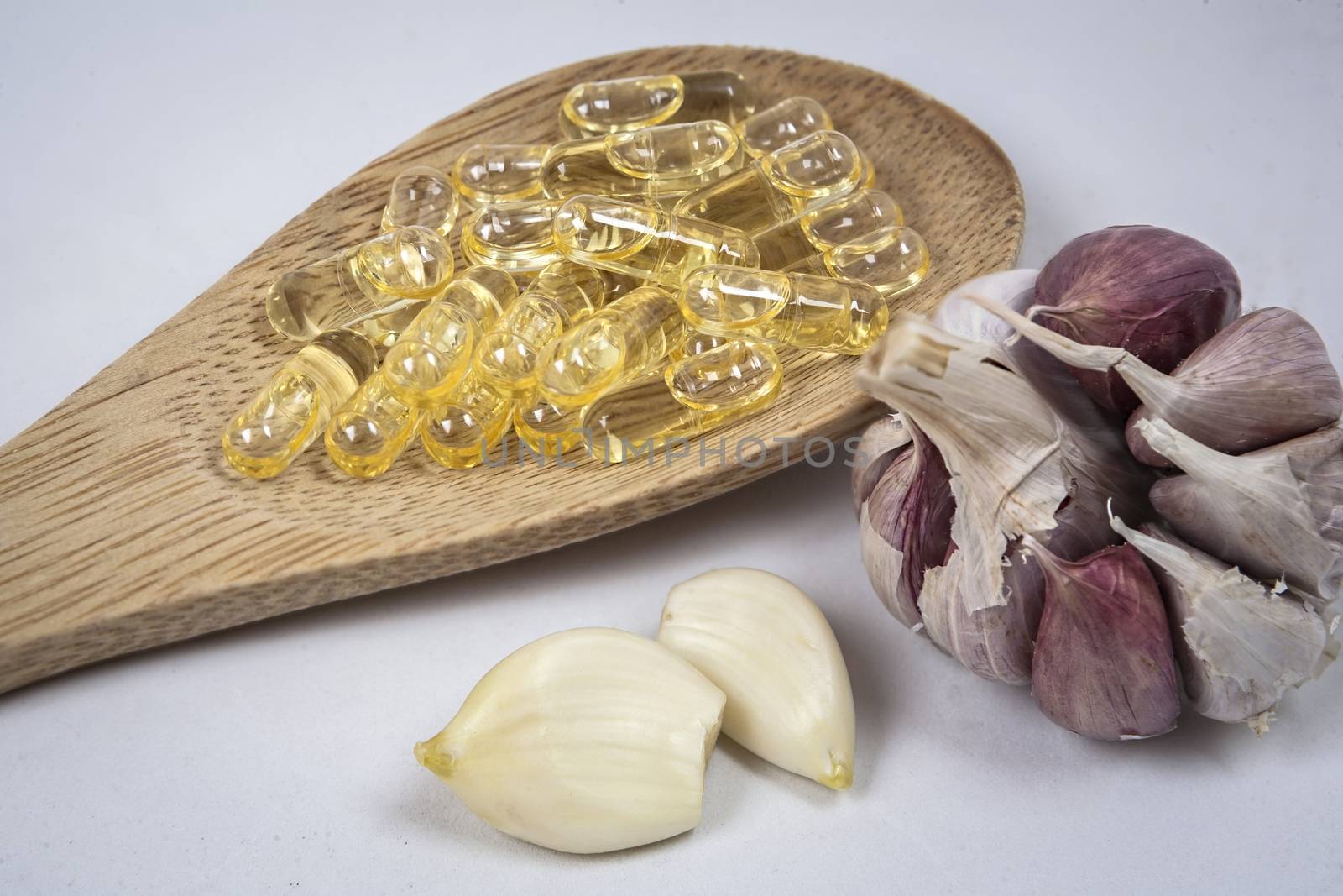 Capsules of garlic oil in a bucket of wood by digicomphoto