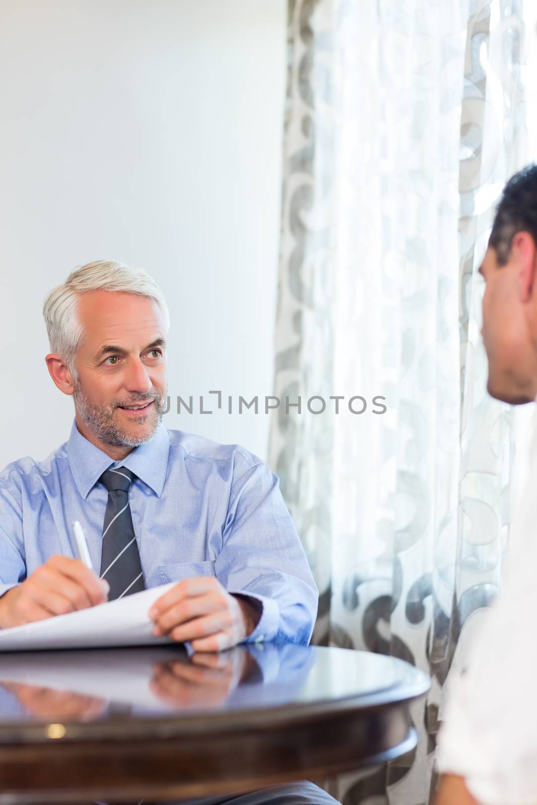 Two businessmen doing paperwork at desk in the office