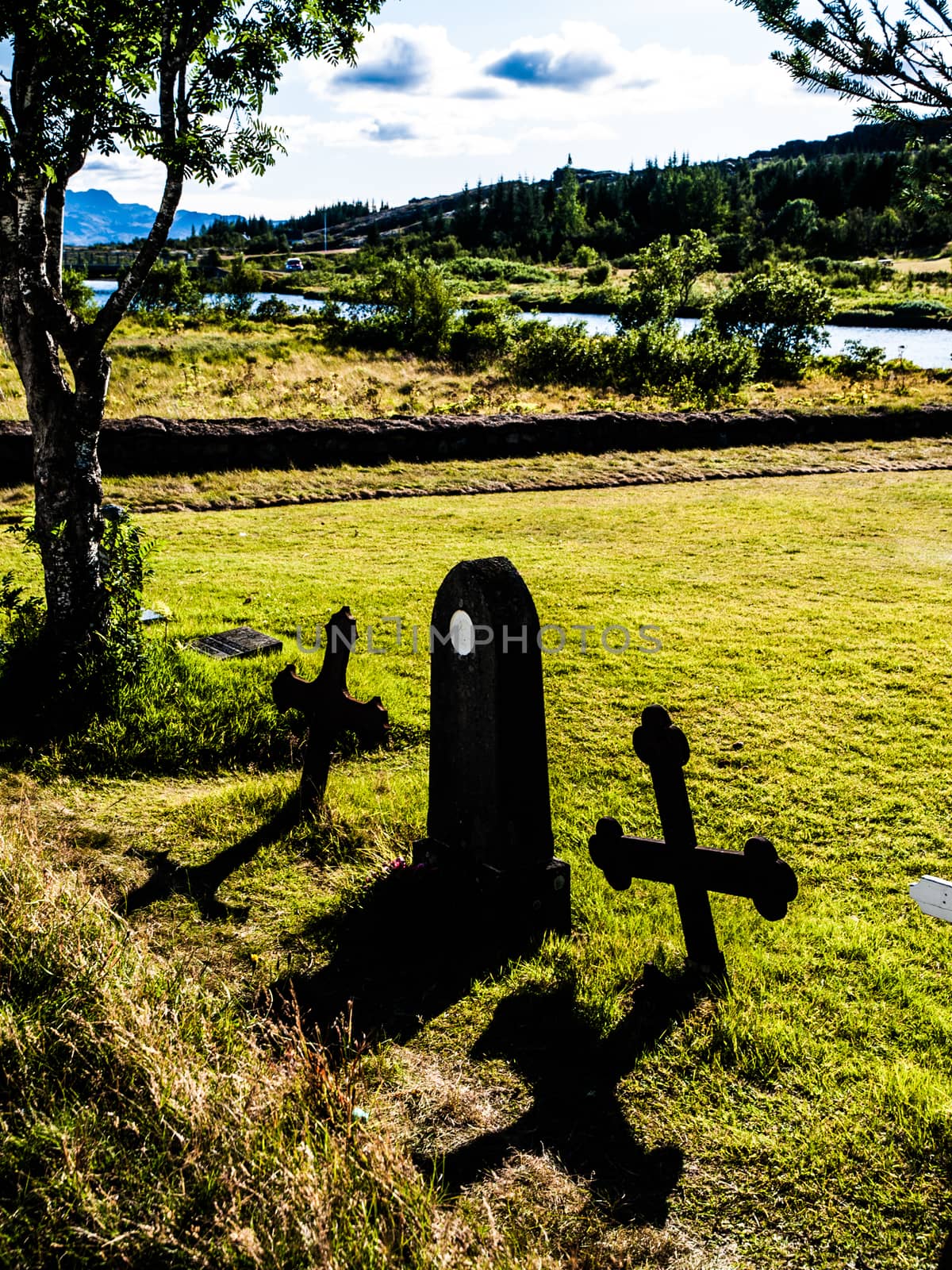 Grave with two crosses in sunny evening