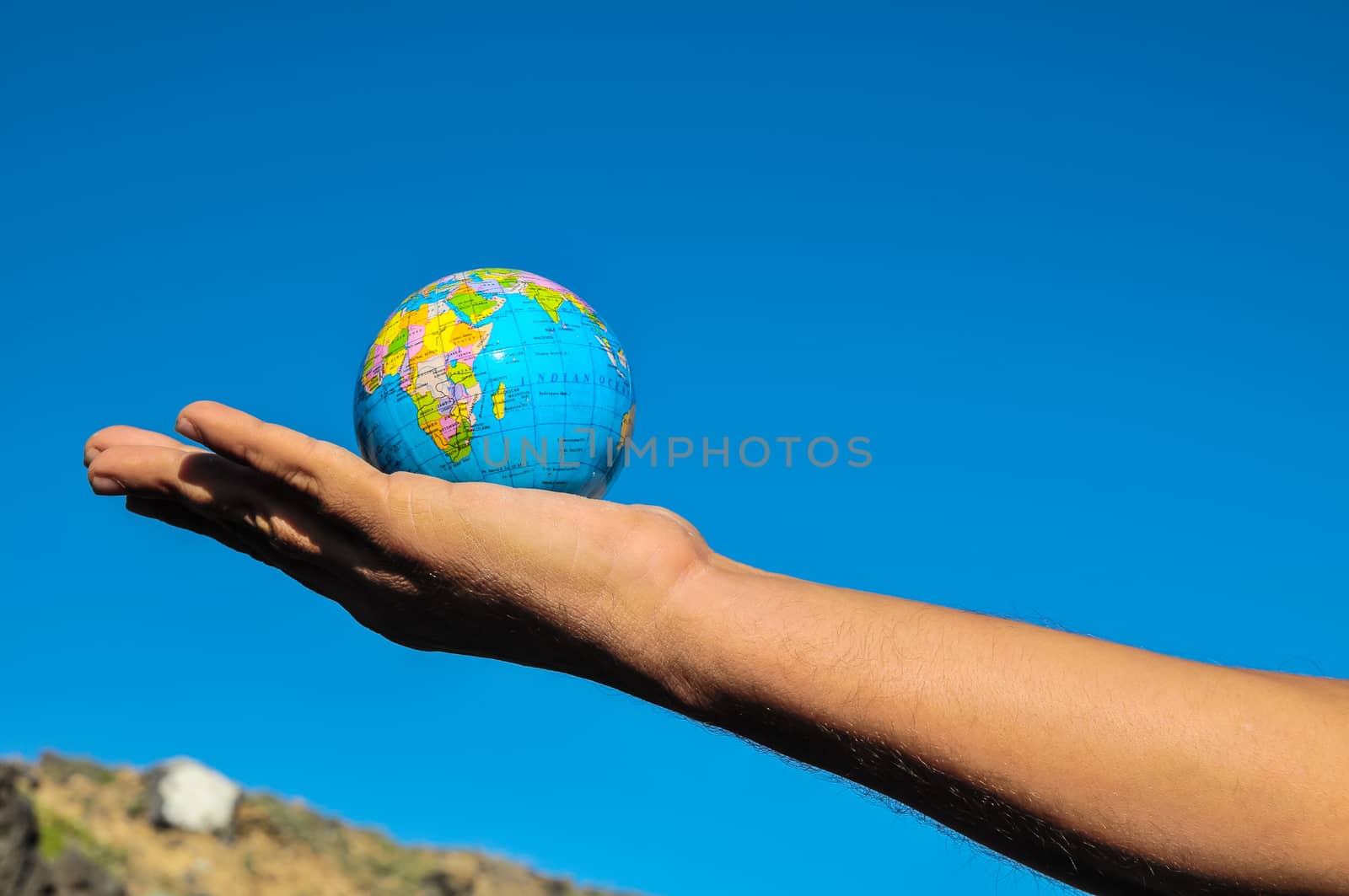 Vintage Old Globe Earth and Human Hand over a Blue Sky