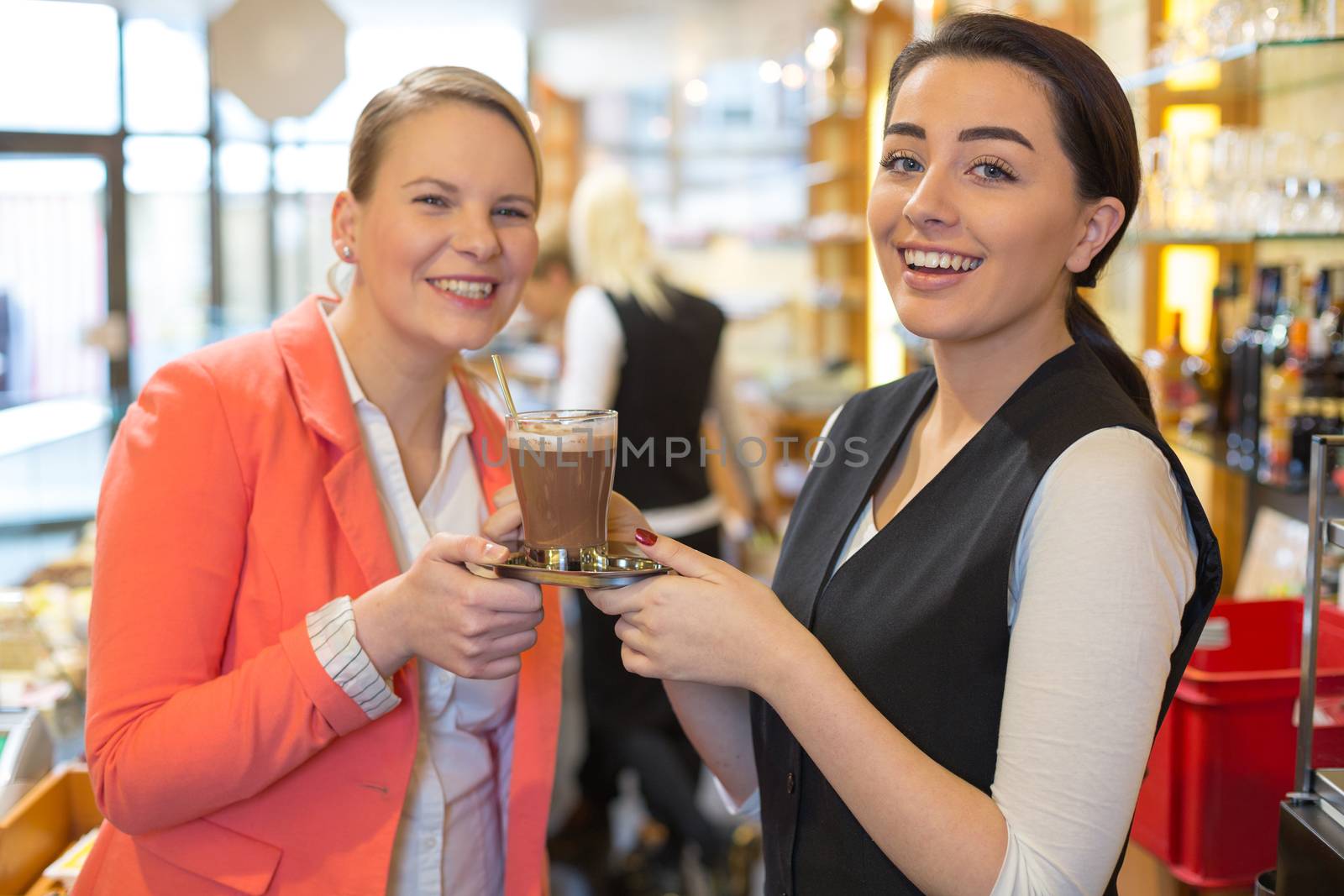 Waitress giving cup of coffee to customer in cafe or restaurant