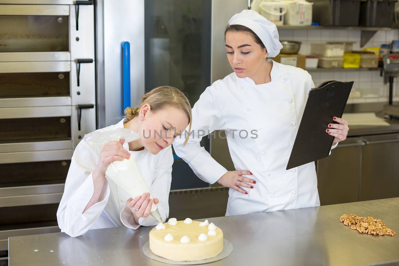 instructor in bakery teaching apprentice by ikonoklast_fotografie