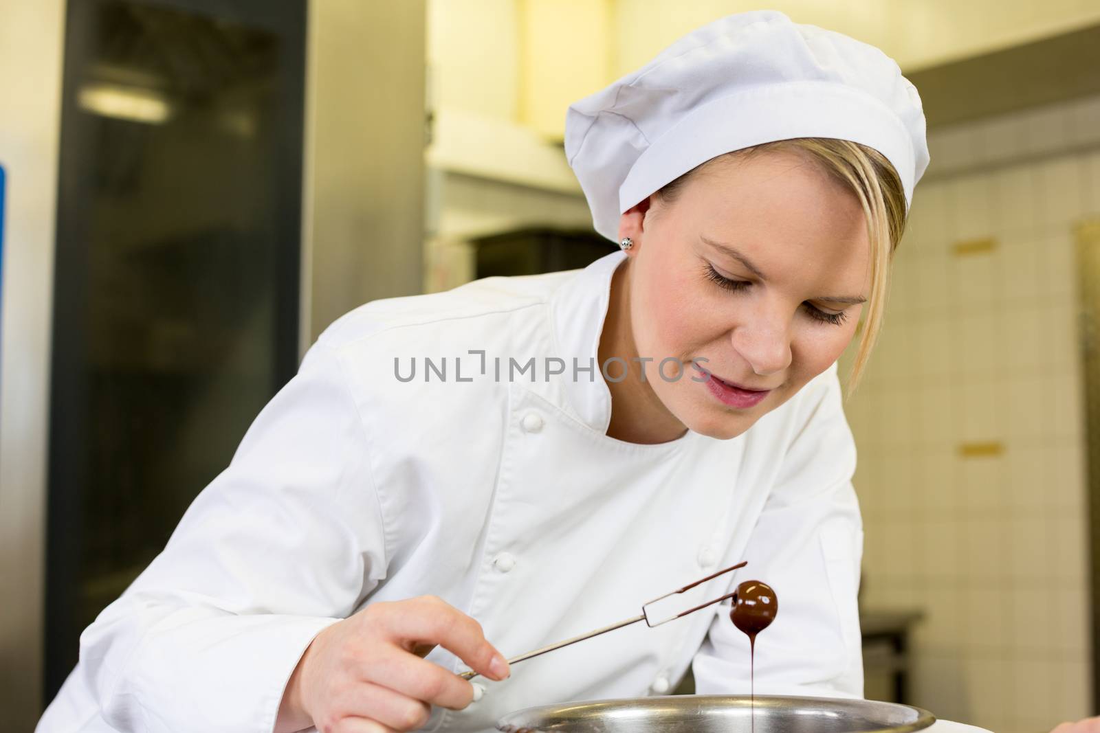 confectioner producing filled chocolates in confectionery