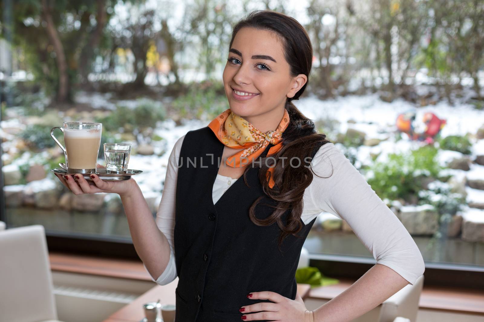 Waitress or server posing with cup of coffee in cafe or restaurant