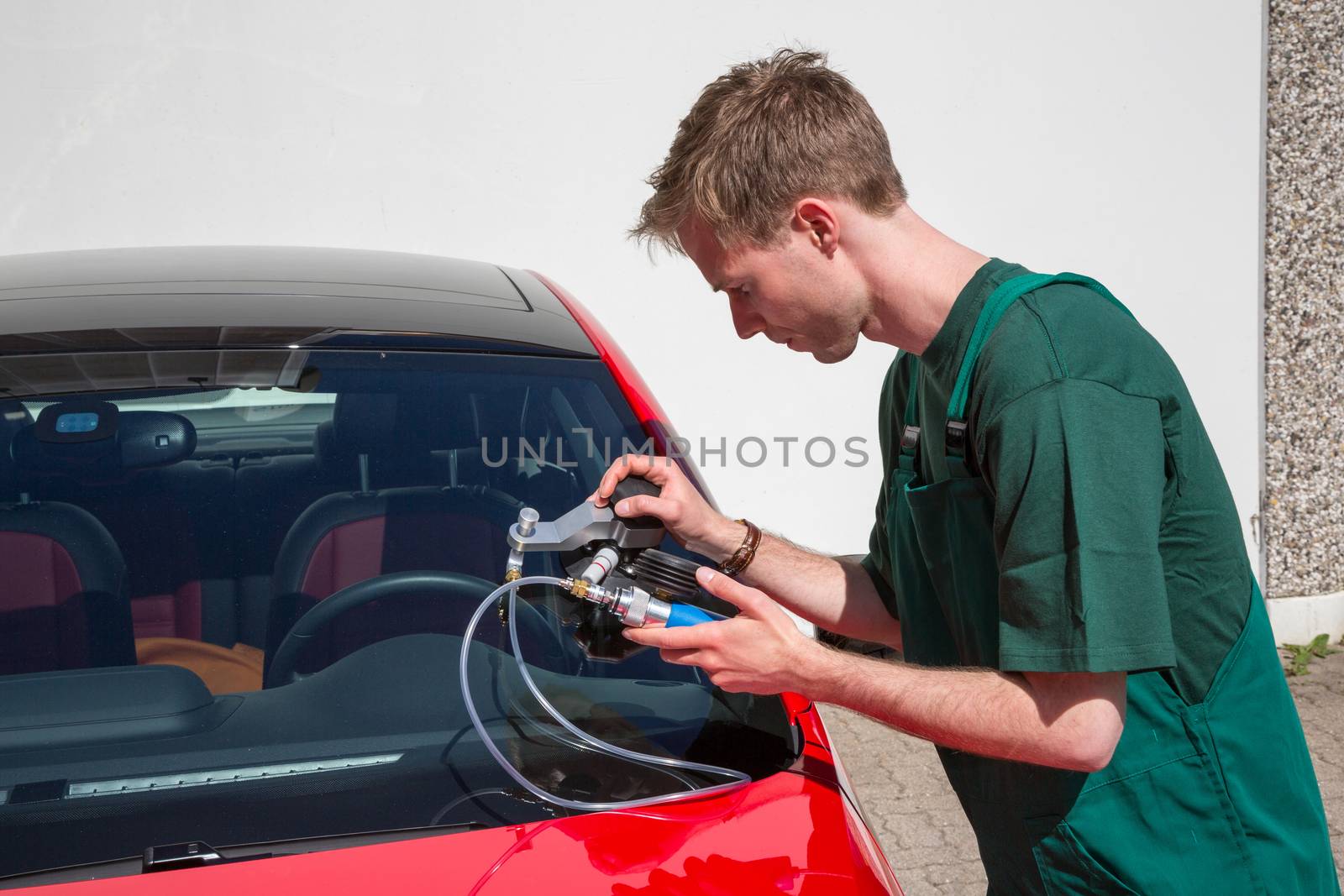Glazier repairing windscreen after stone chipping damage by ikonoklast_fotografie