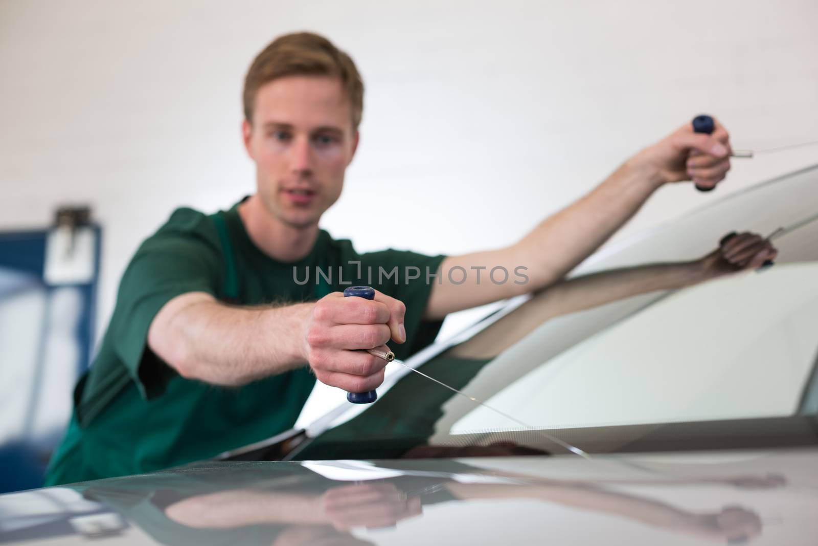 Glazier removing windshield by ikonoklast_fotografie