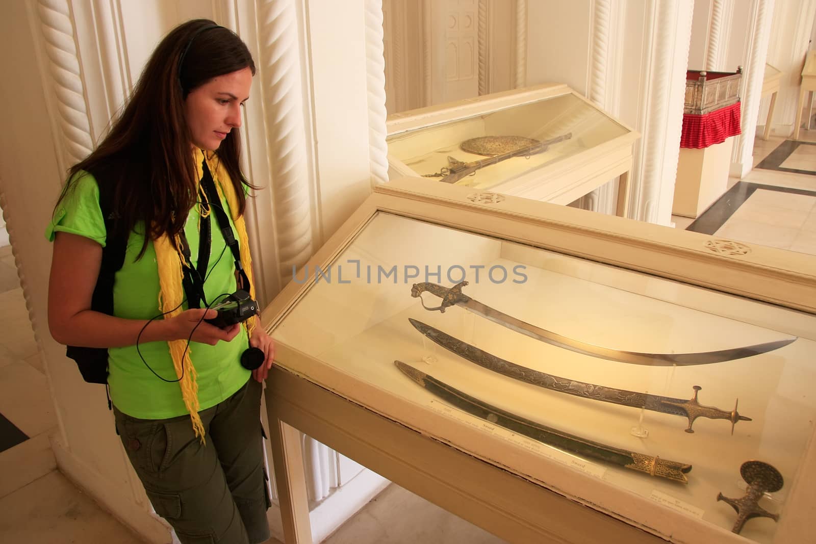 Tourist looking at display of swords, Mehrangarh Fort museum, Jodhpur, Rajasthan, India