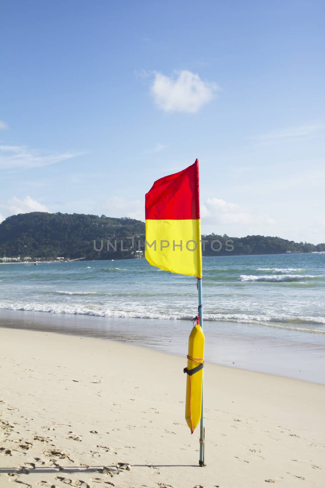 Season of storms. warning flag on the beach  by wyoosumran