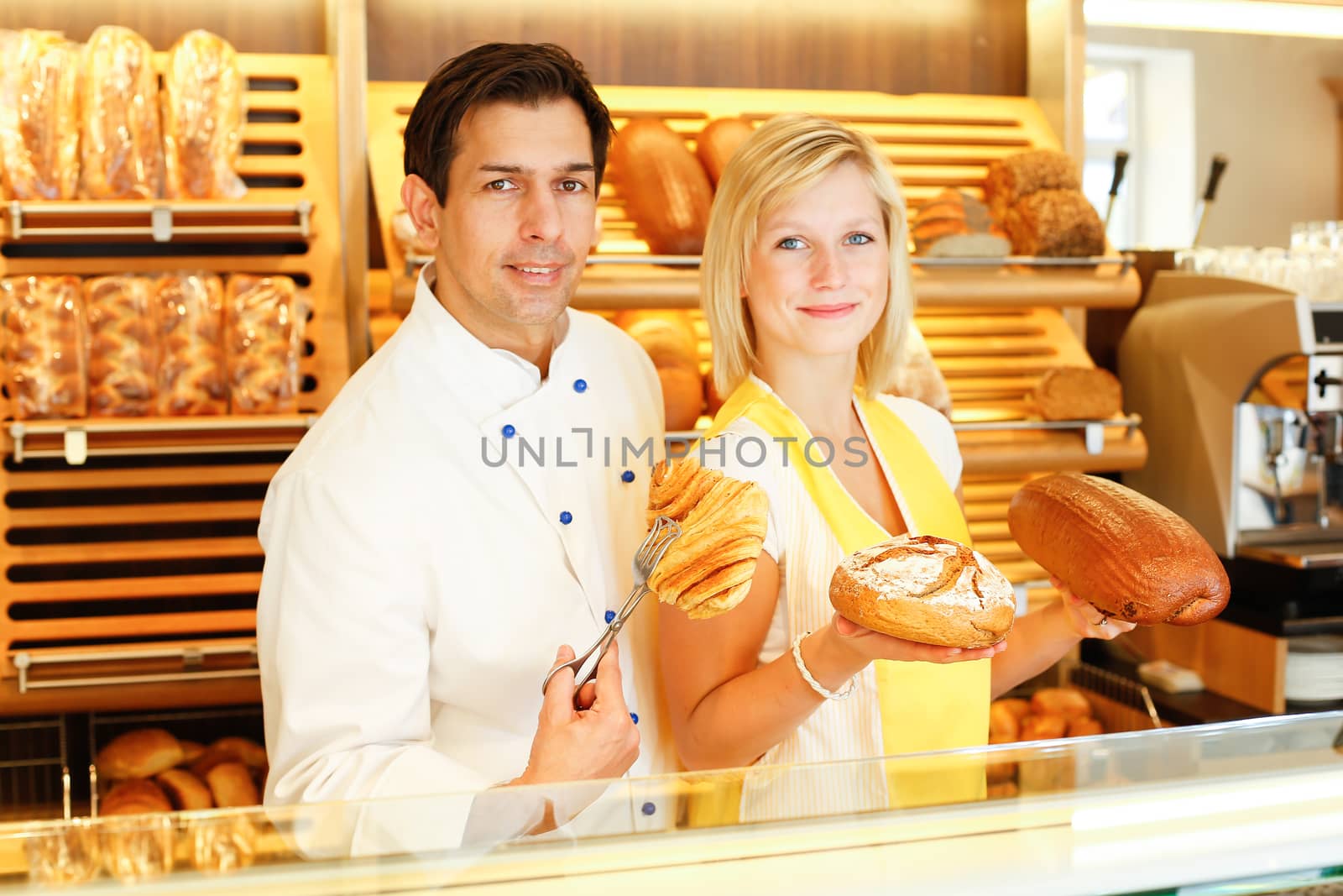 Baker and shopkeeper present pastry by ikonoklast_fotografie