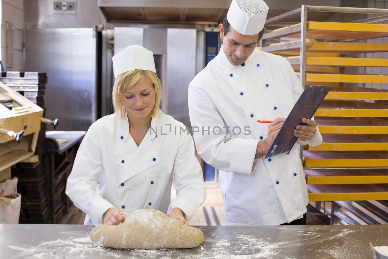 Instructor watching an apprentice kneading dough
