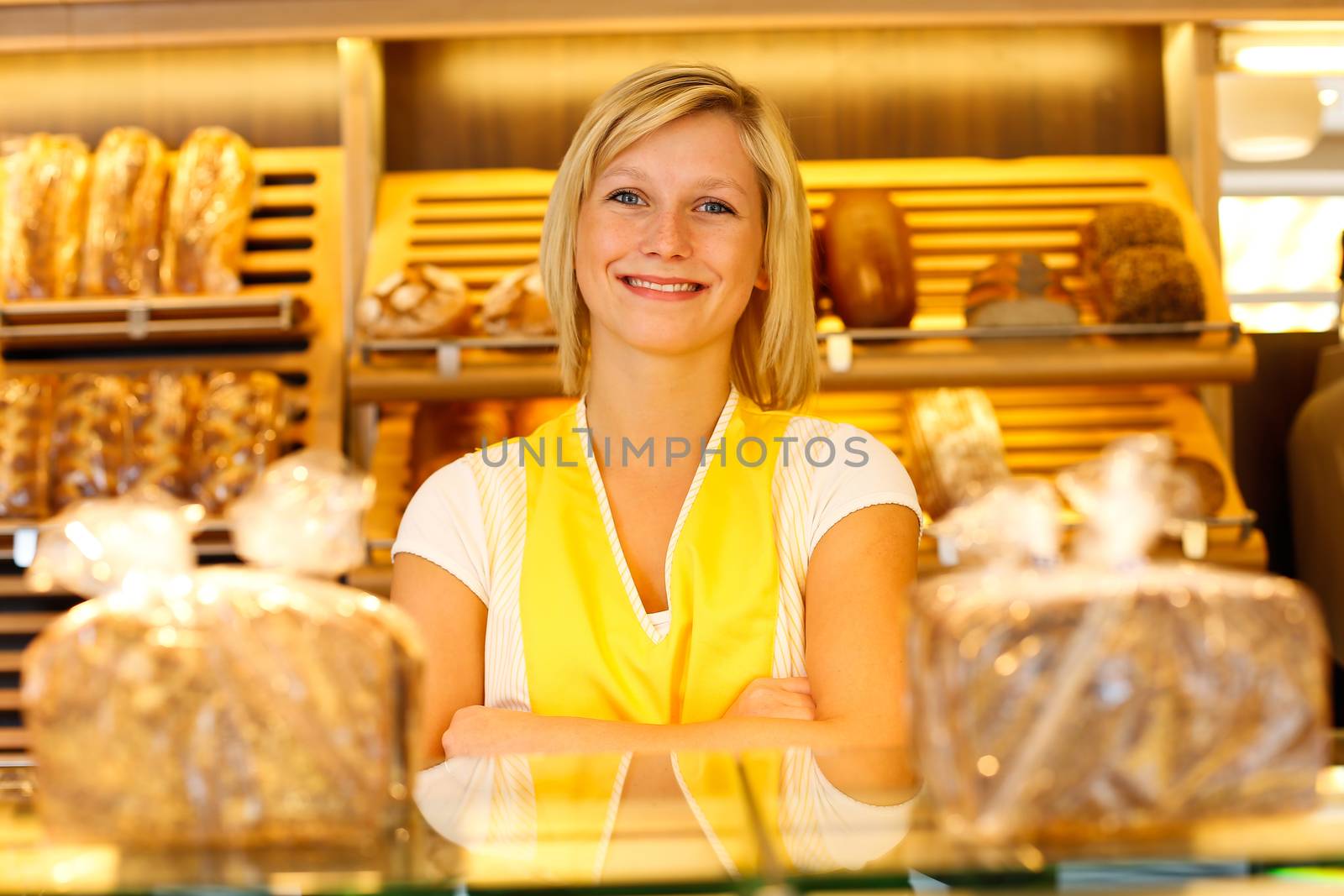 Bakery saleswoman or shopkeeper posing in baker's shop