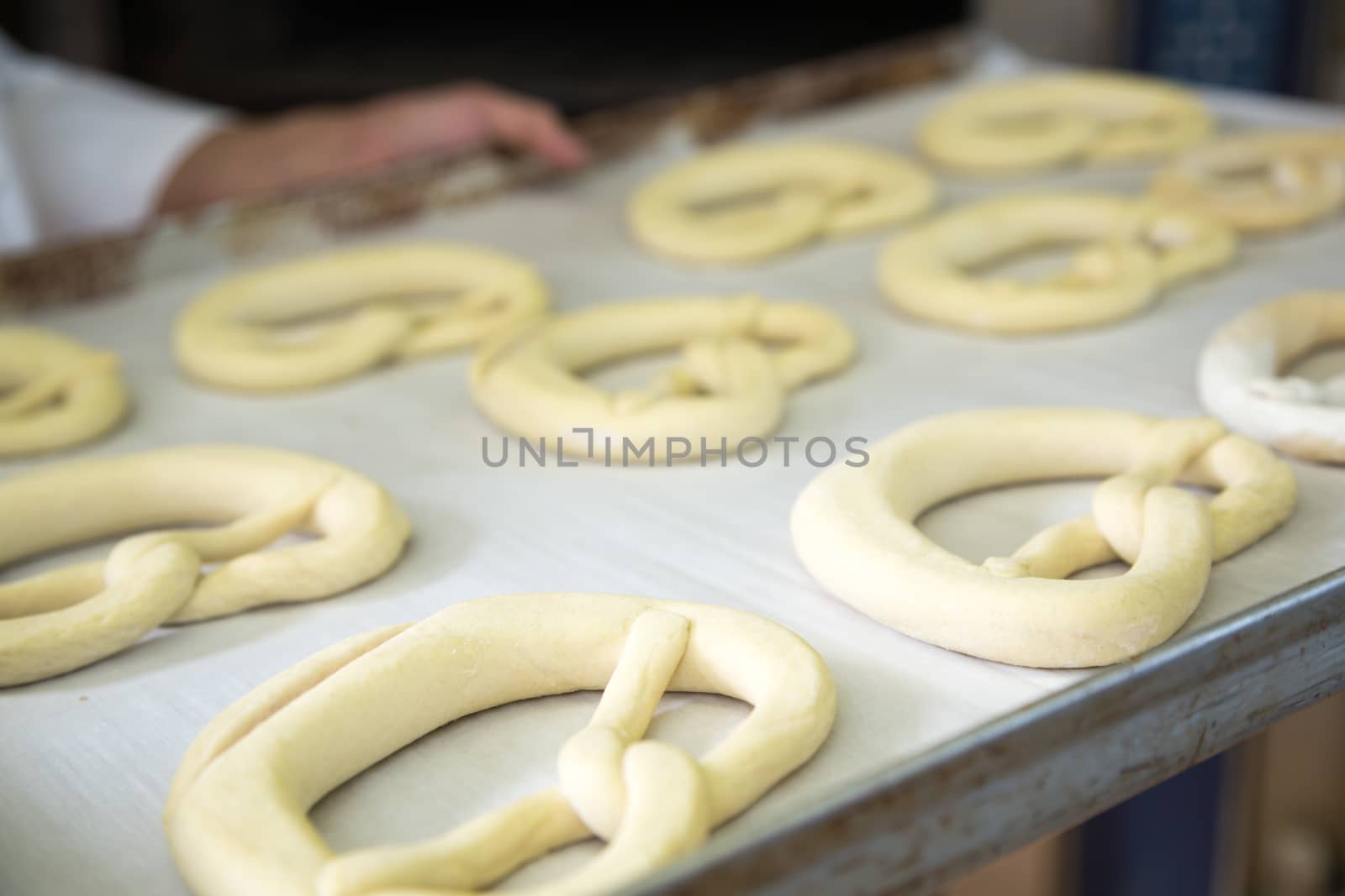 A tablet with pretzel dough in bakery by ikonoklast_fotografie