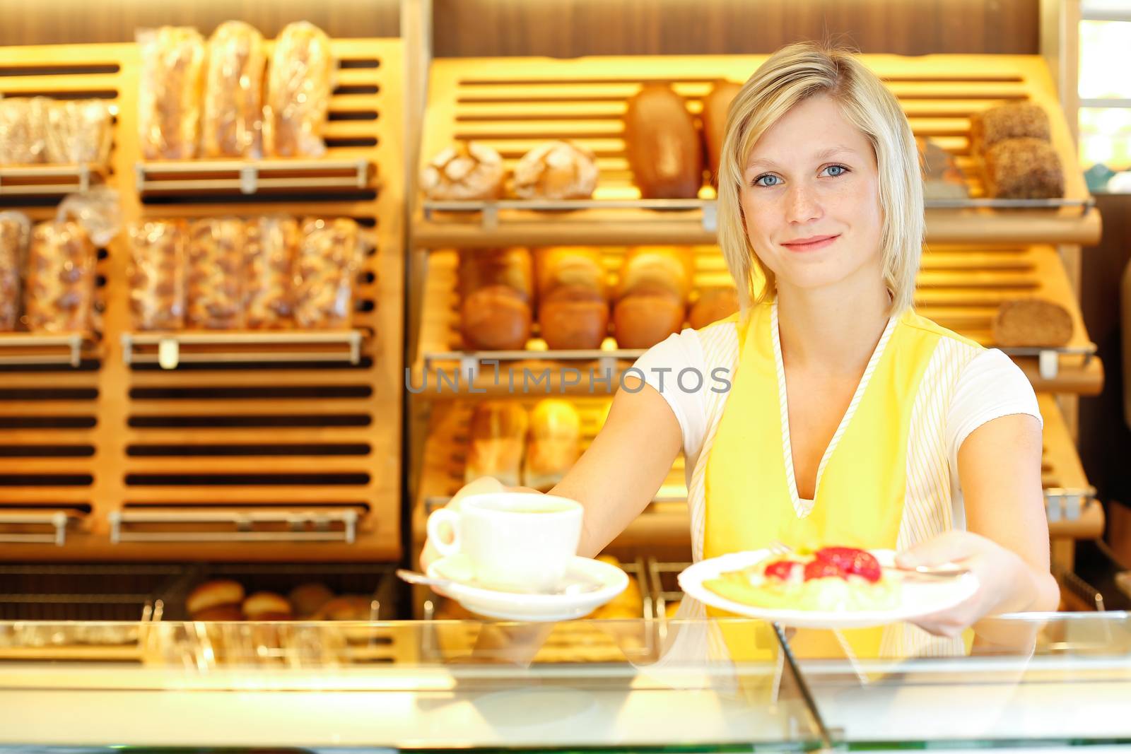 Shopkeeper in baker's shop preparing coffee and cake by ikonoklast_fotografie