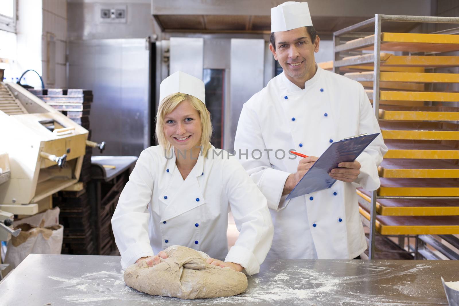 Instructor watching an apprentice kneading dough