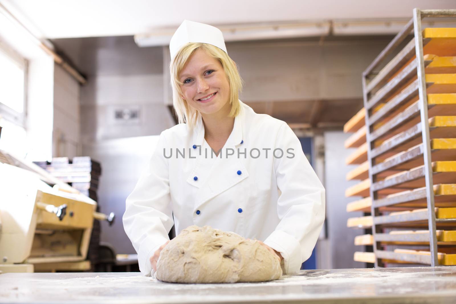 Baker kneading dough in bakery by ikonoklast_fotografie