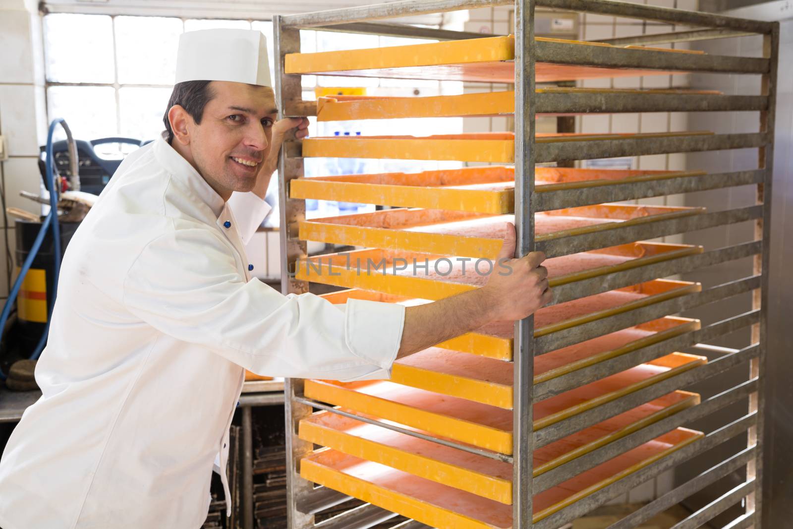 Baker with large rack for bread in a bakery