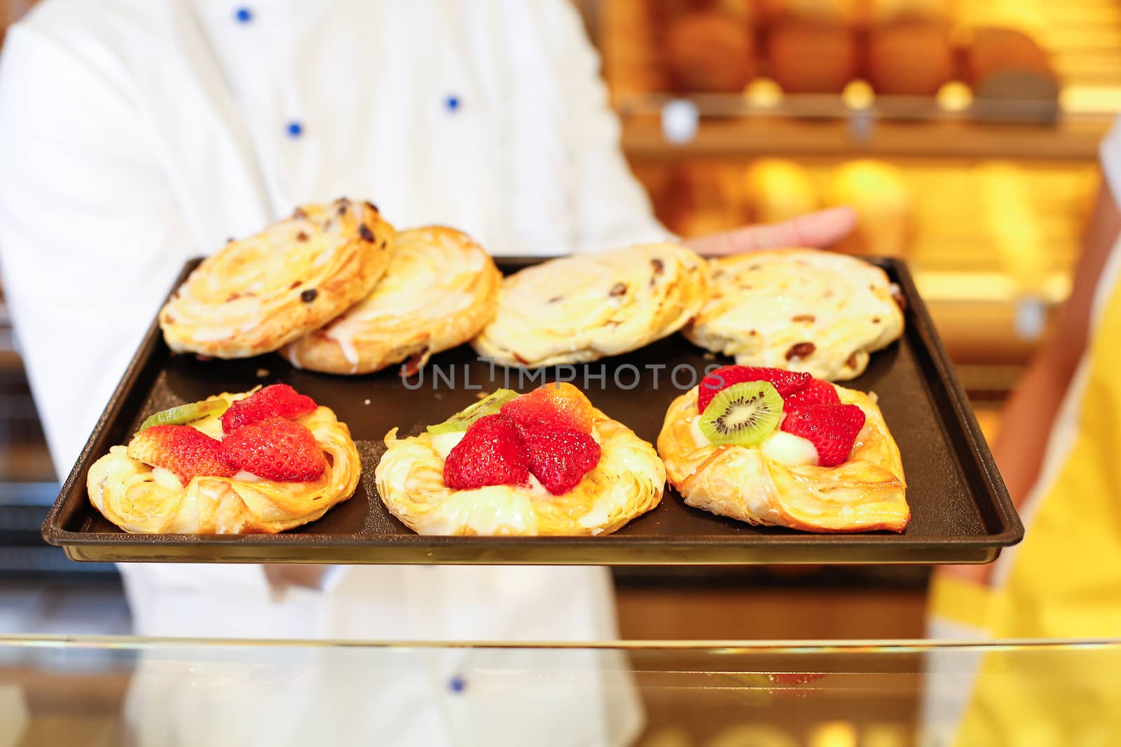 Baker and shopkeeper present pastry by ikonoklast_fotografie