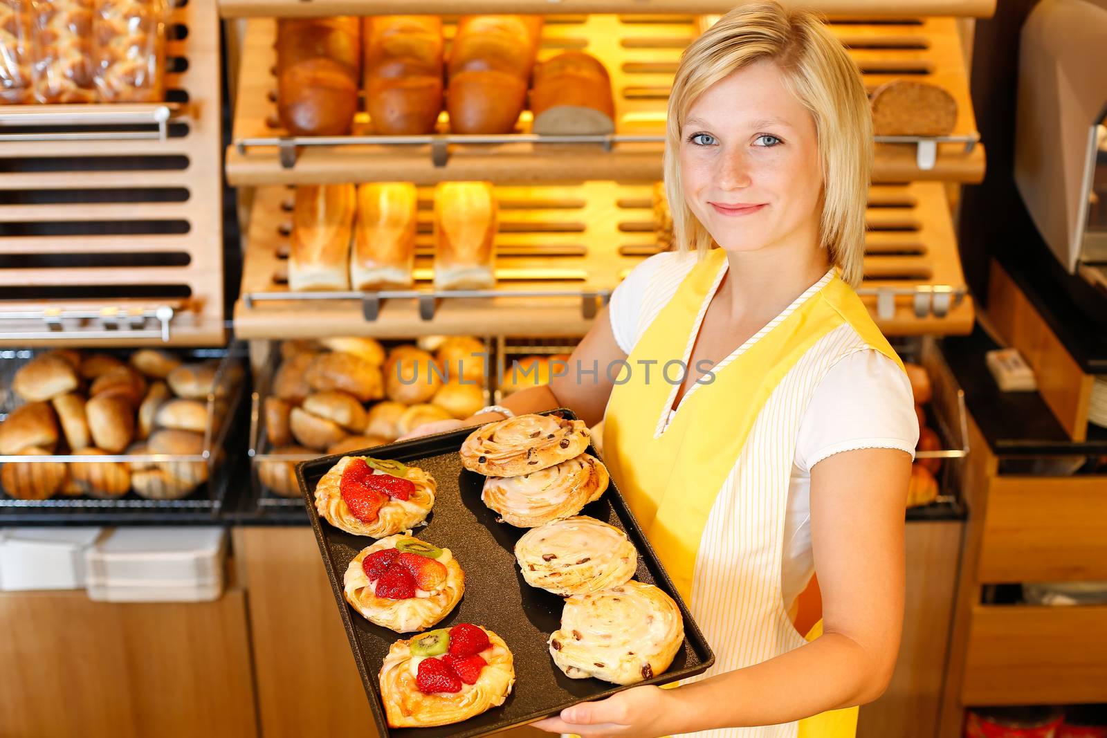 Bakery shopkeeper present different types of cake or pastry