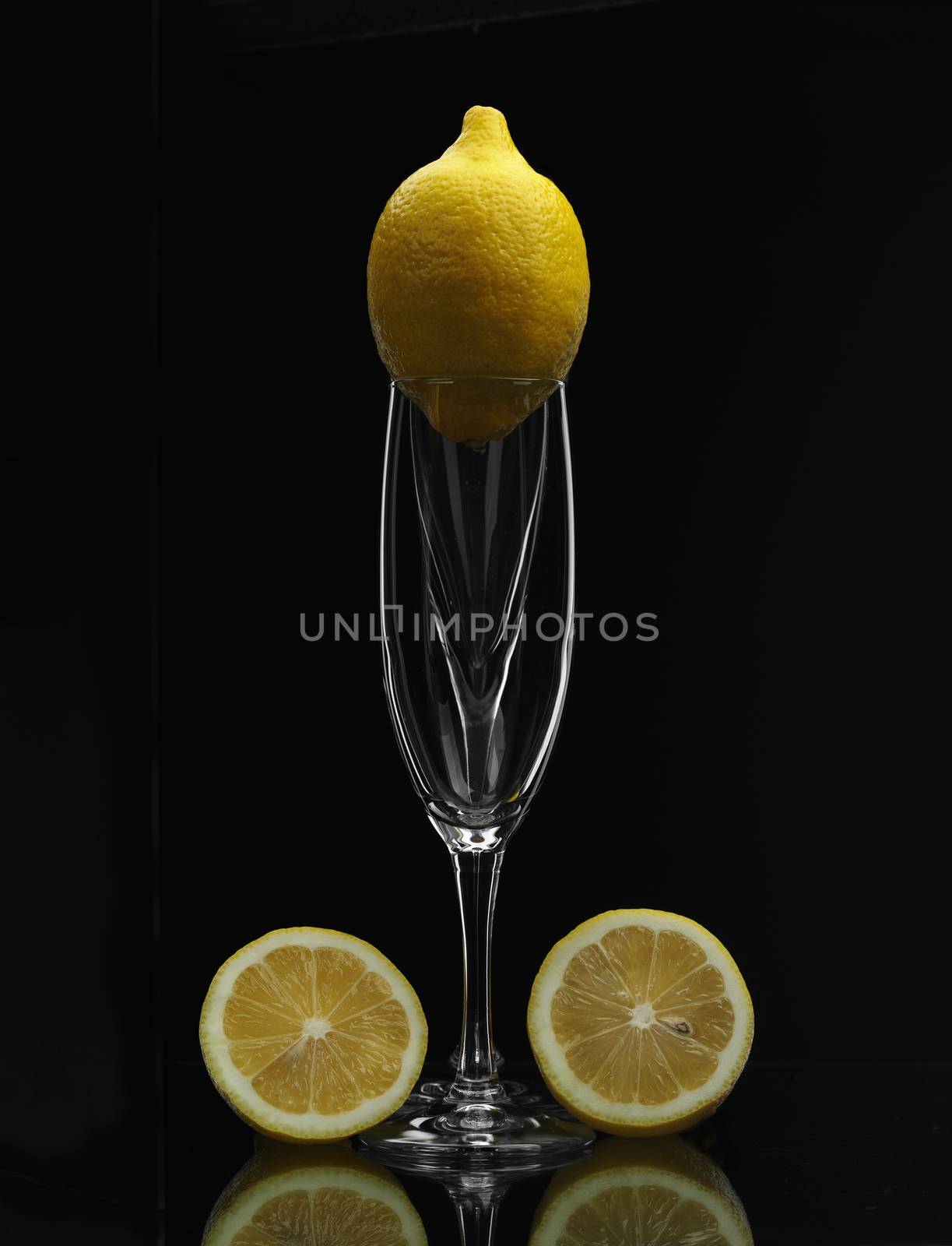 lemon on champagne glass over black background

