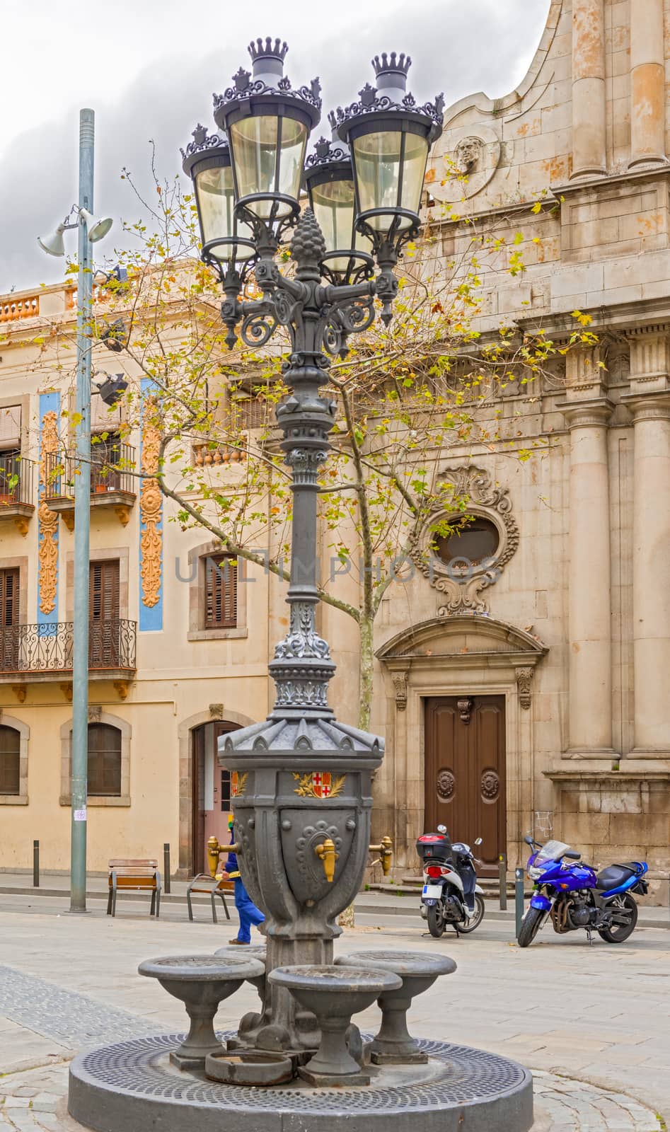 Ornate street light in front of La Parroquia San Miguel del Porto a catholic church in Barcelona, Spain on January 25, 2014