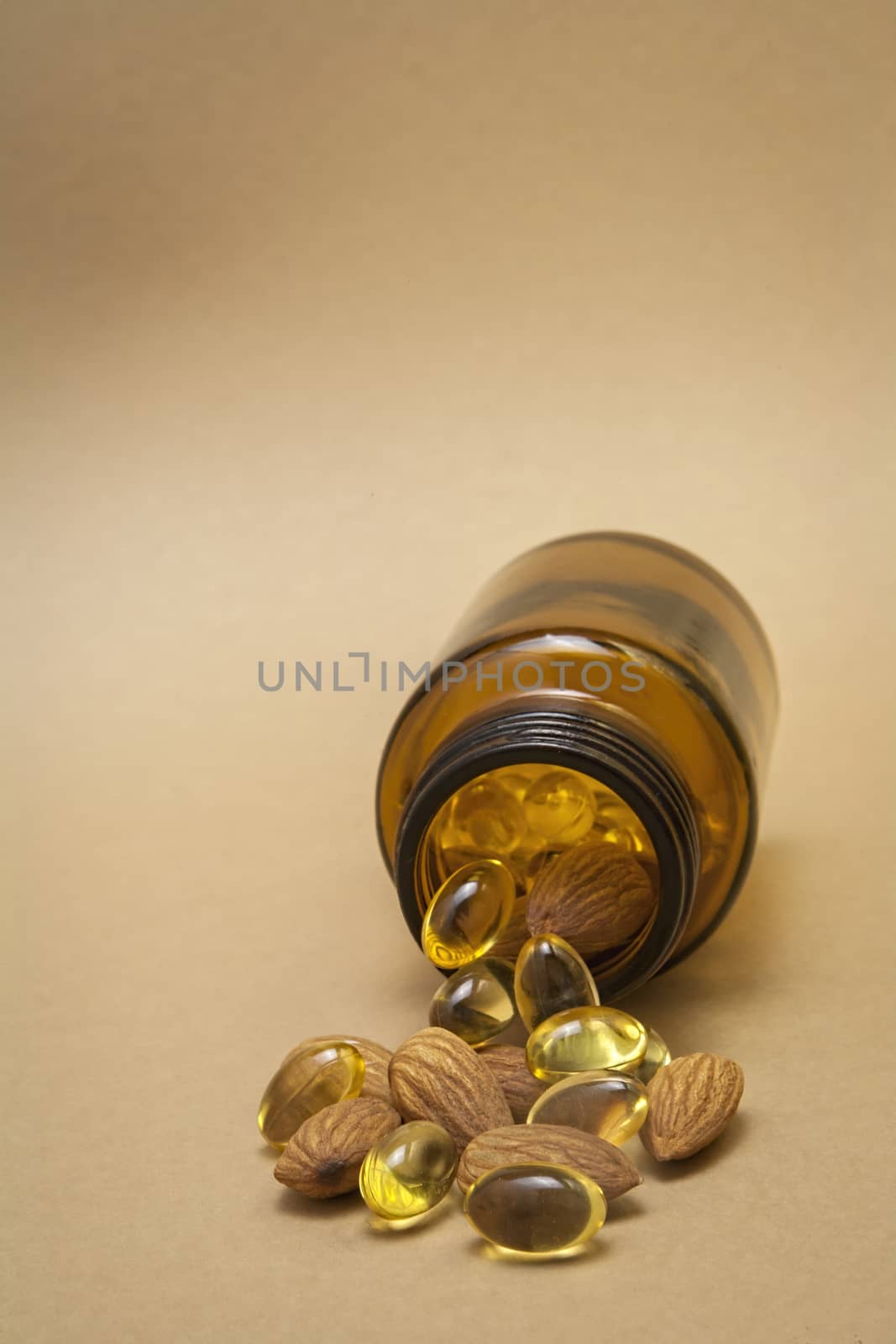 Almond oil in capsules isolated on brown background