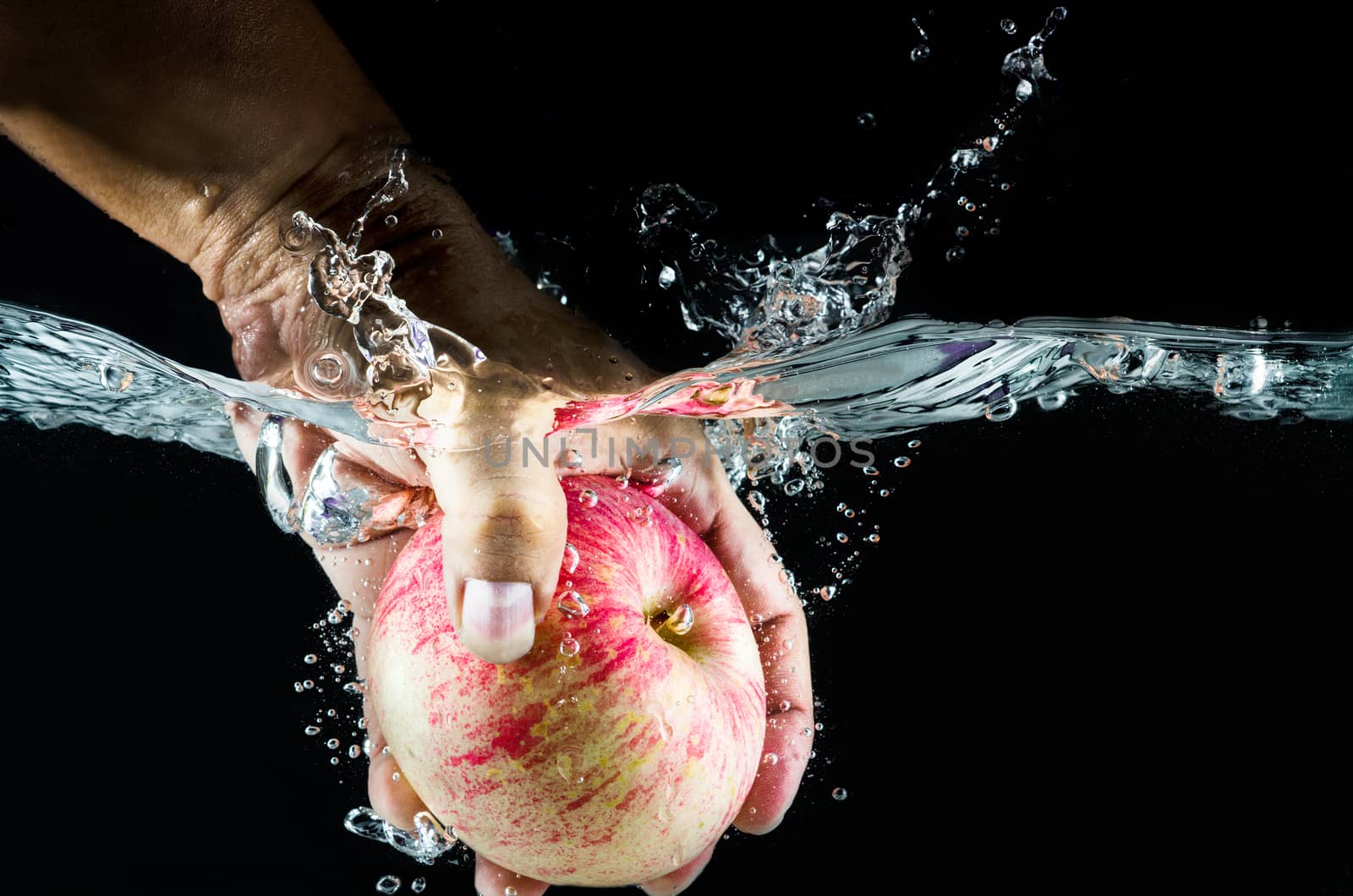 hand take up Apple splashing in water.  by 9george