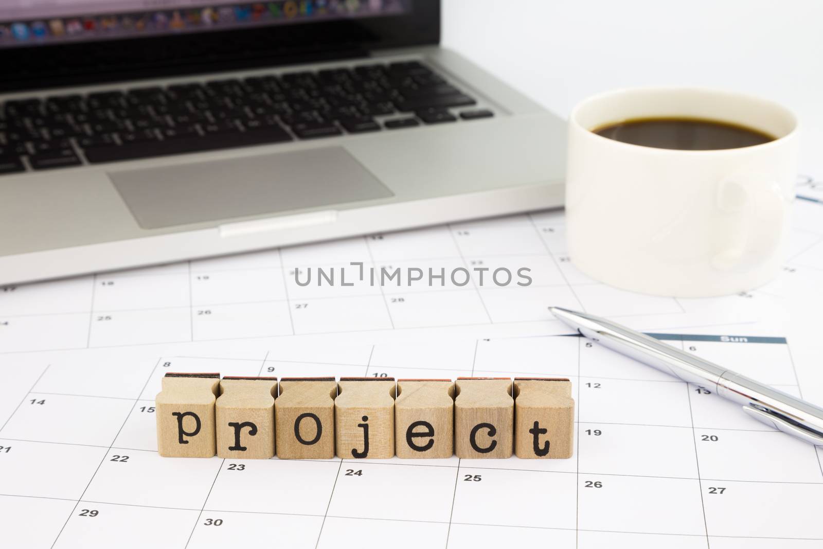 project wording, calendar and laptop on office table by vinnstock