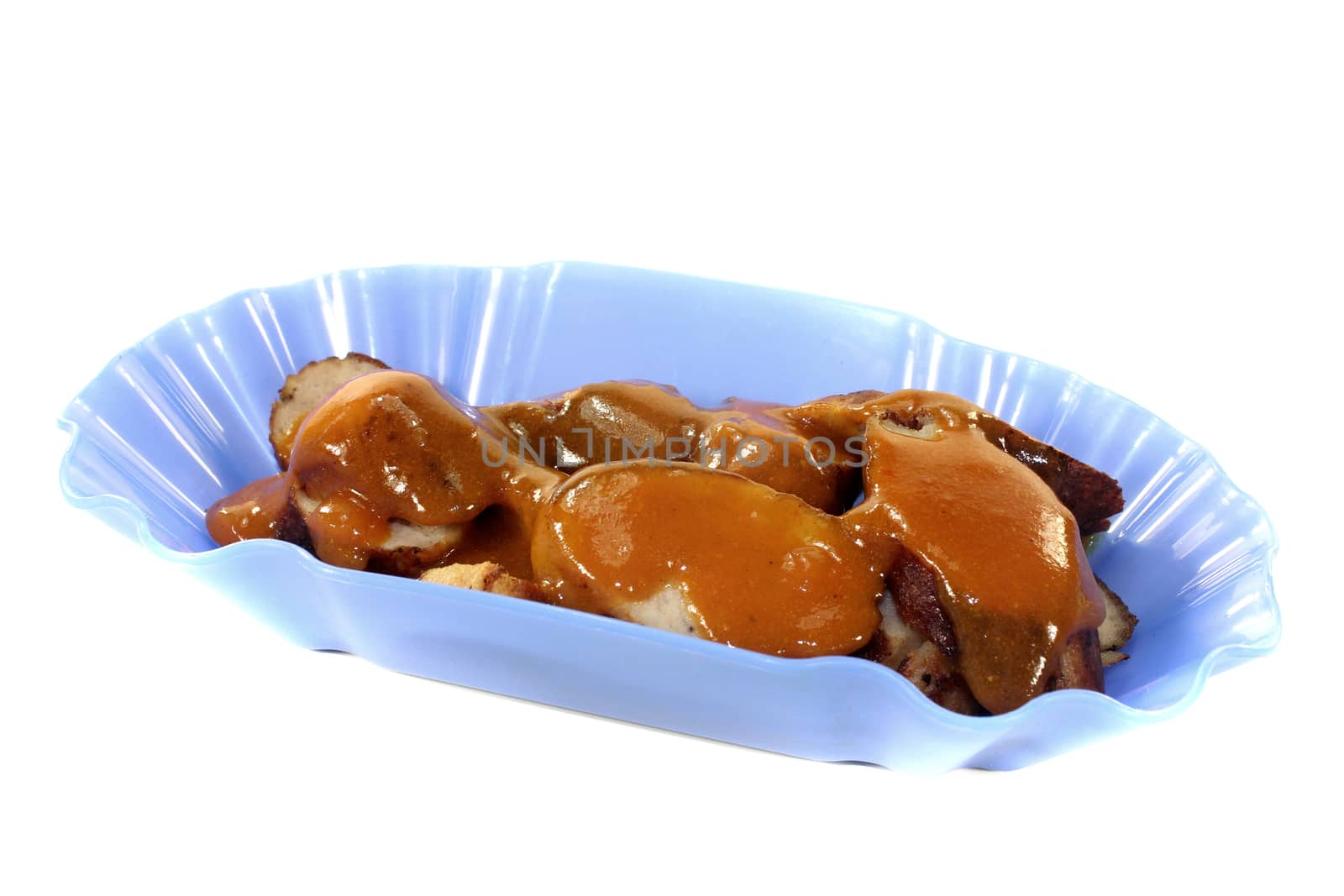 Sausage with curry in a bowl on a light background