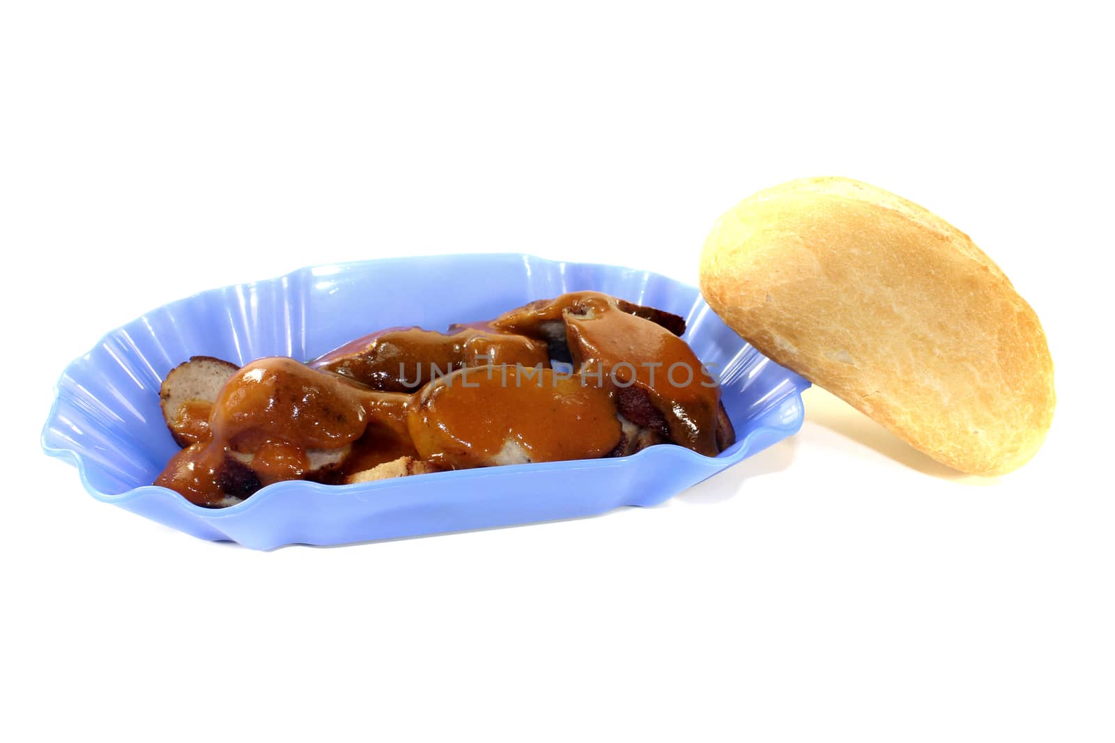 Currywurst with bun in a bowl on a light background