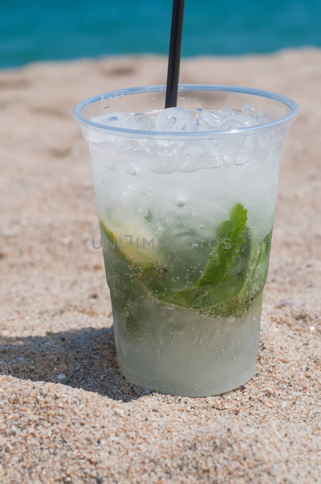 Shot of Mojito cocktail on the beach