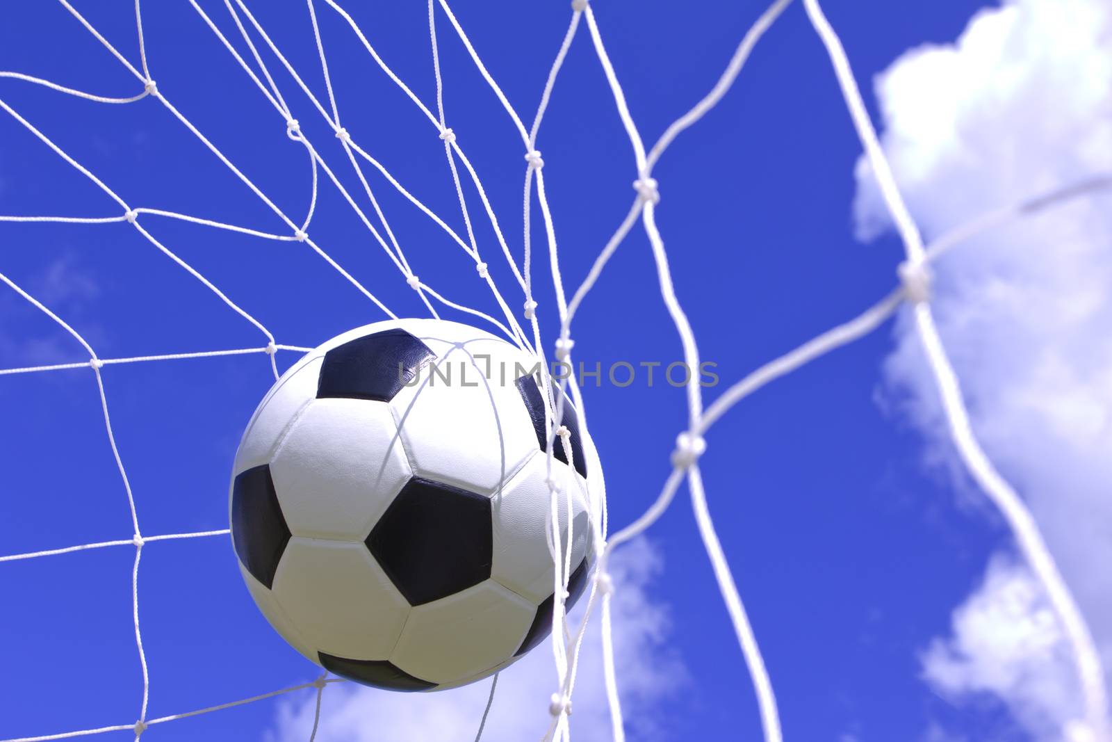 soccer ball in net on blue sky by wyoosumran