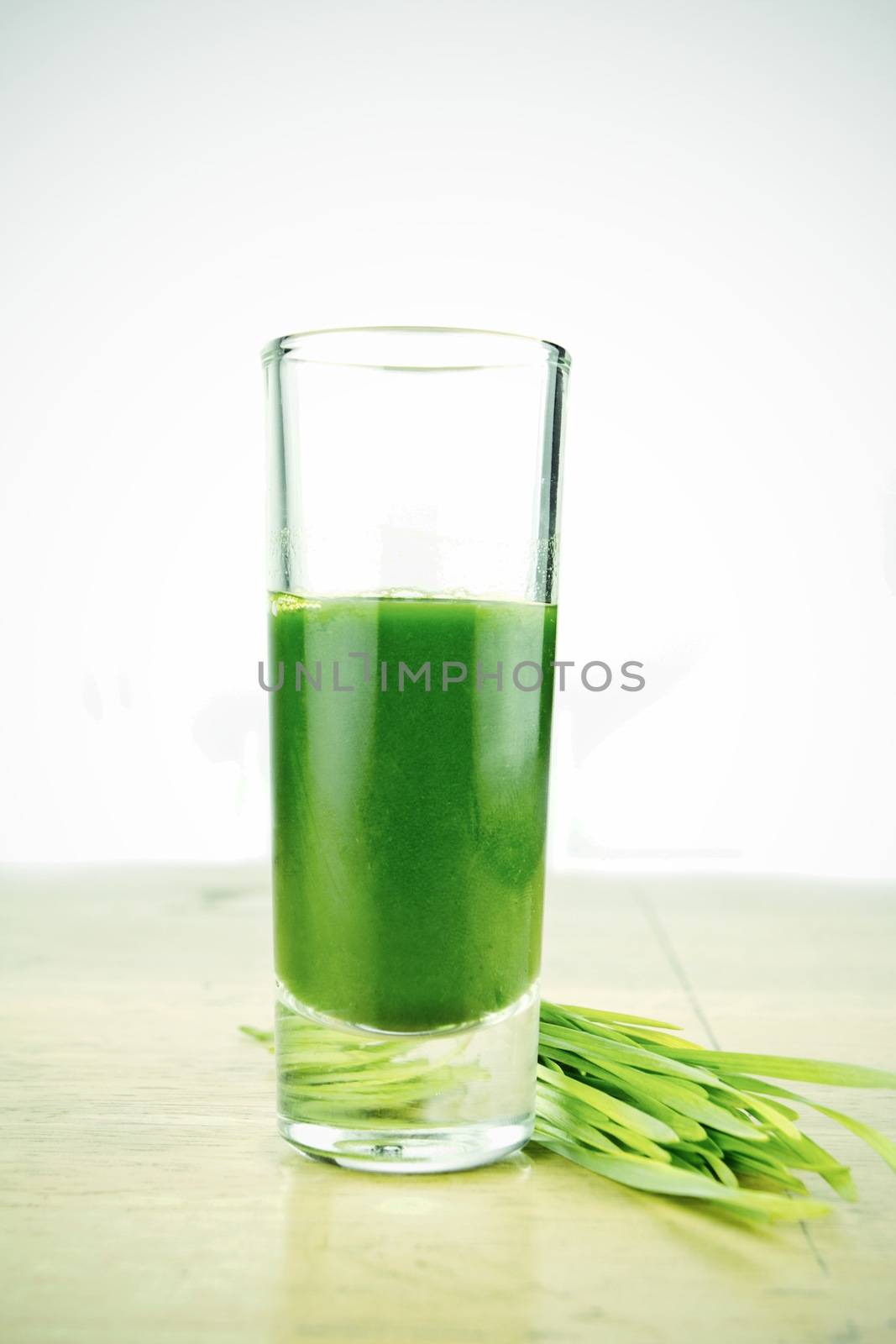 Wheathgrass juice on wood background